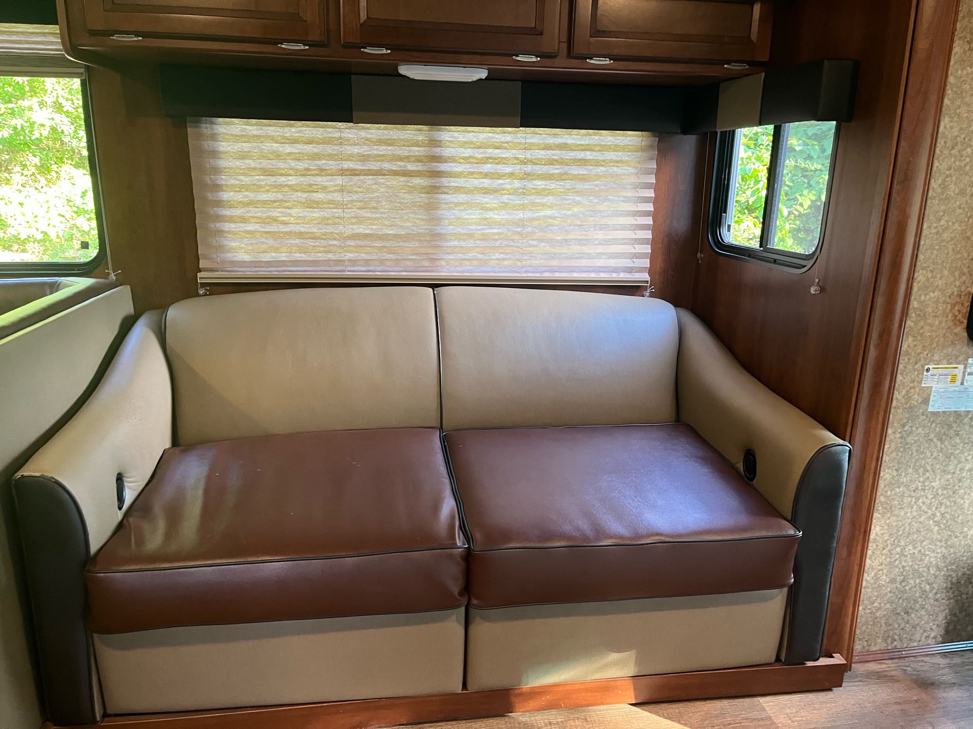 Spacious brown & tan RV sofa inside a clean RV rental, offering comfortable seating for your next road trip.. Forest River FR3 2015