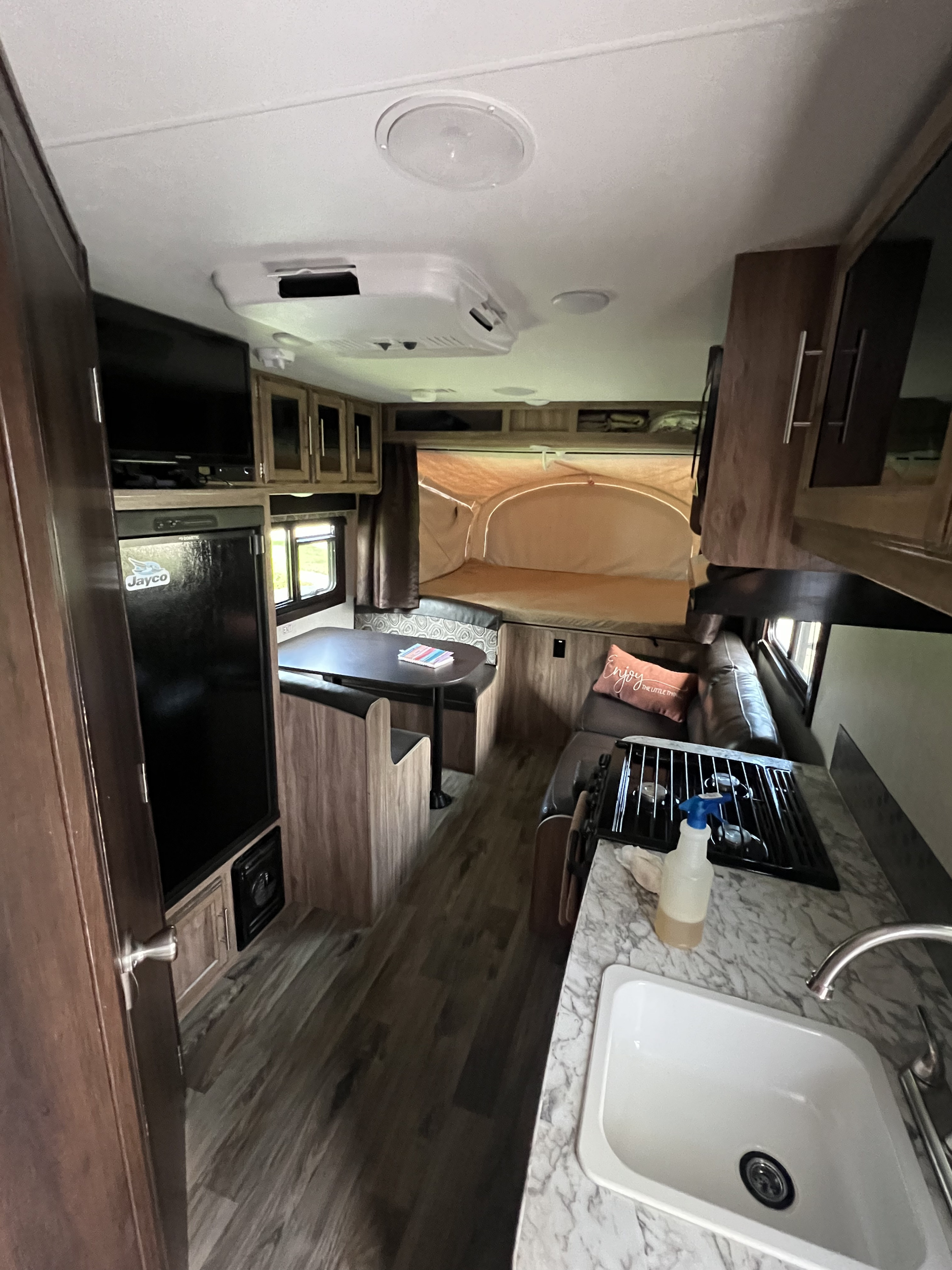 Explore this RV rental's inviting interior: complete with a well-equipped kitchen, comfy dinette, and sleeping space.. Jayco Jay Feather 2018
