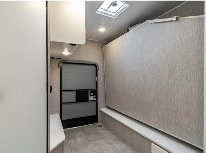 RV rental interior: Light-toned walls, main entrance door, built-in bench, overhead lights, and a unique sleeping partition.. Coachmen Cross Trail 2021