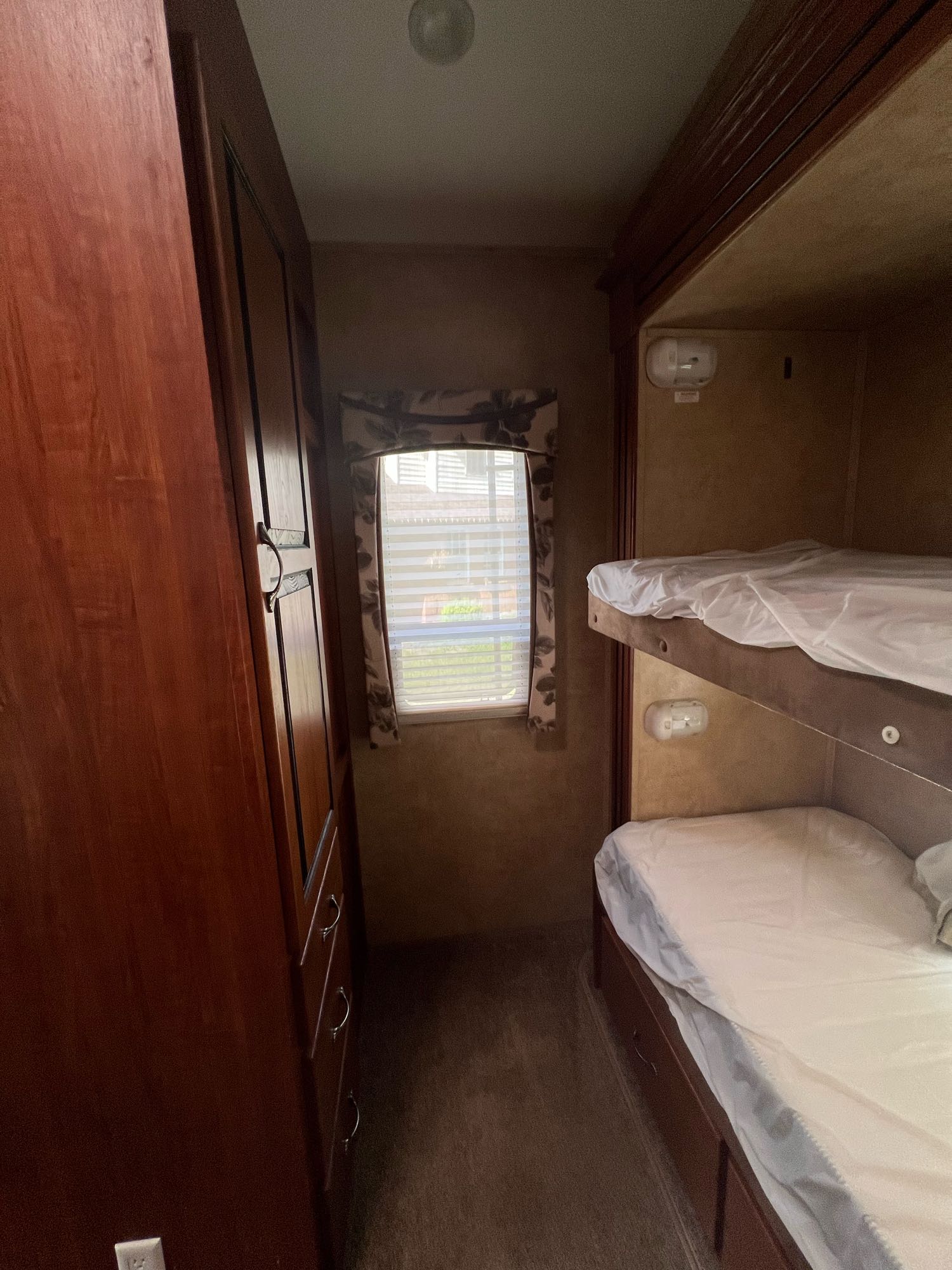 Explore this RV rental's cozy bunk beds, complete with white linens, alongside a built-in storage cabinet and window.. Jayco Eagle 2011