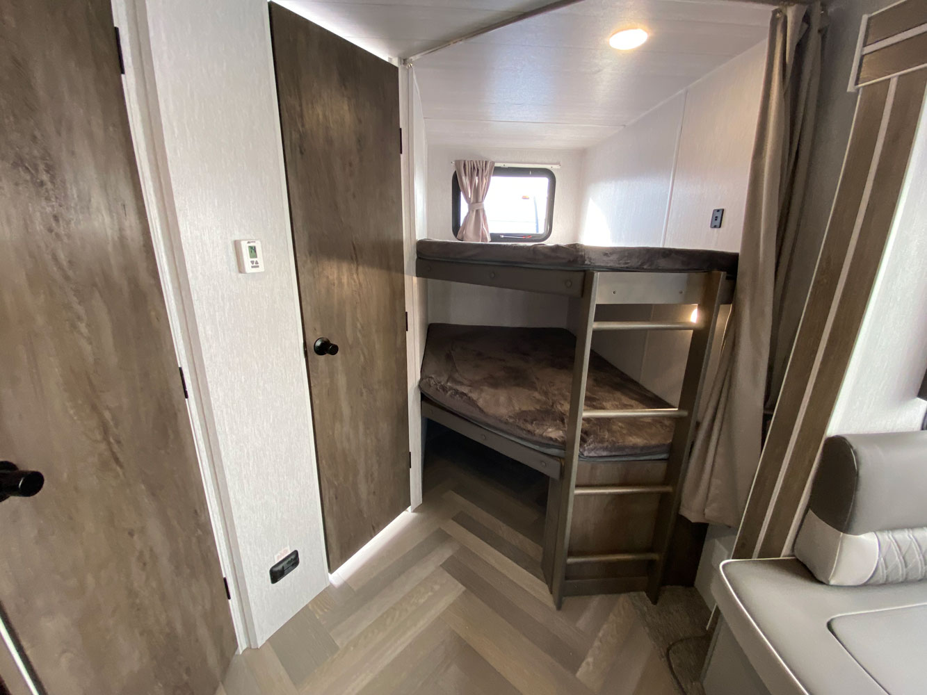 Compact RV rental interior featuring cozy bunk beds, a ladder, and light wood flooring. Ideal for family adventures.. Forest River Salem 2022