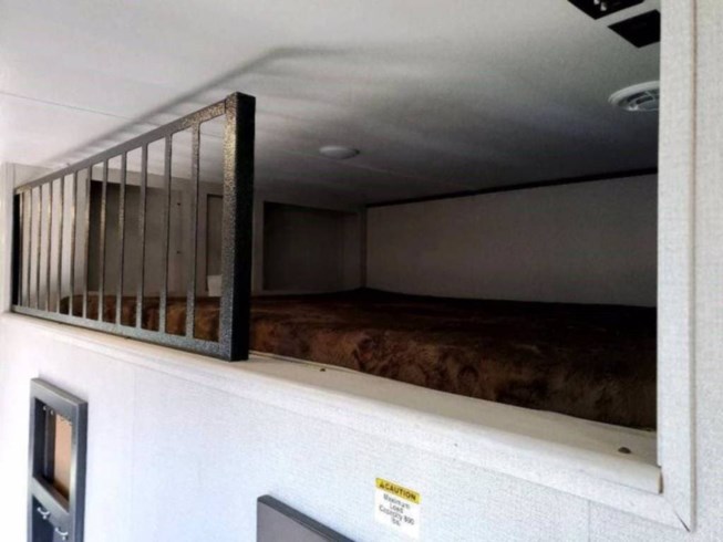 Cozy upper bunk bed in an **RV rental**, featuring a safety railing and brown mattress. Ideal compact sleeping area with 300 lbs capacity.. Keystone RV Sprinter Limited 2022