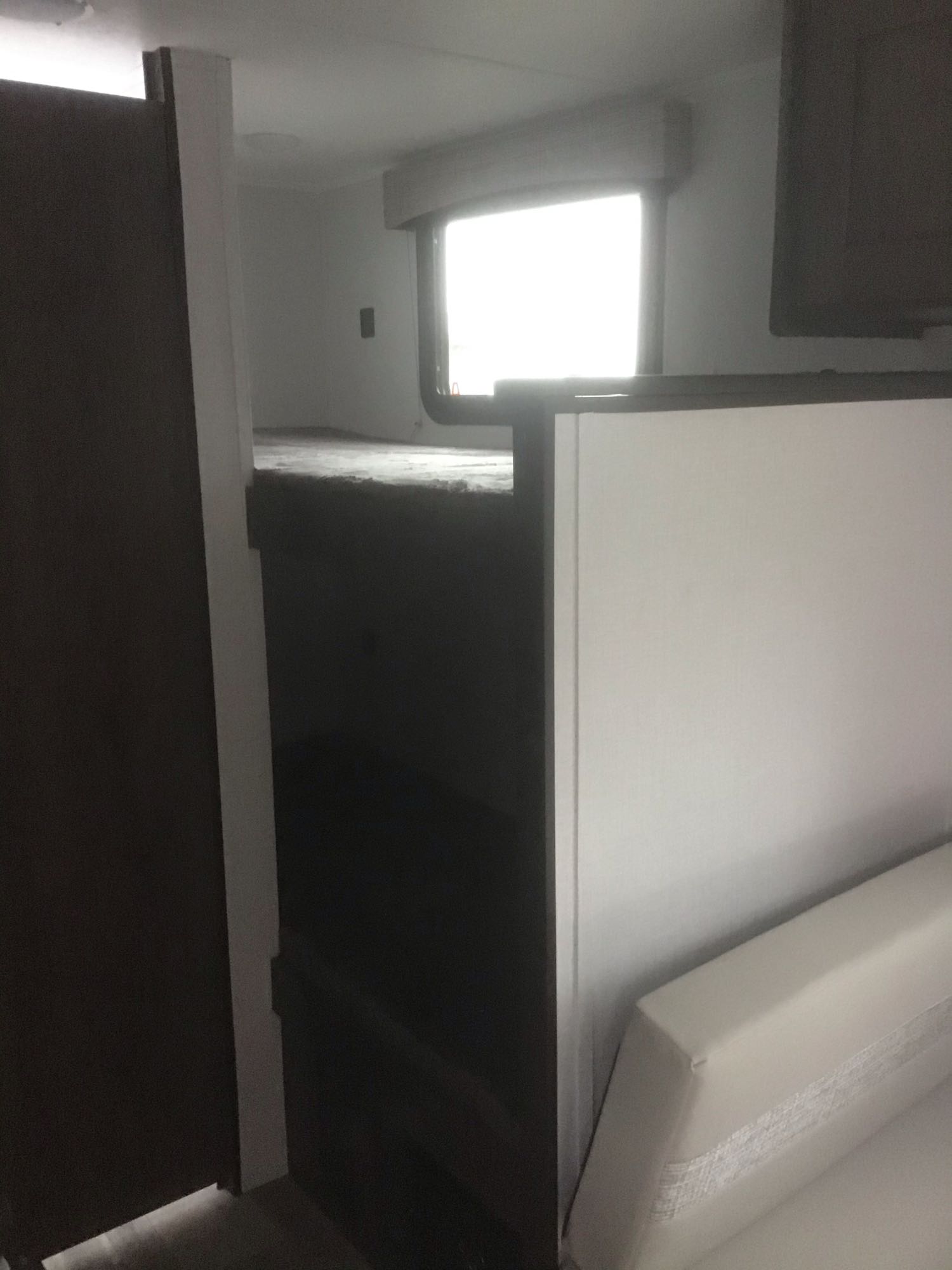 Bright window illuminates an RV rental's cozy bunk bed and seating area.. Forest River Viking 2022