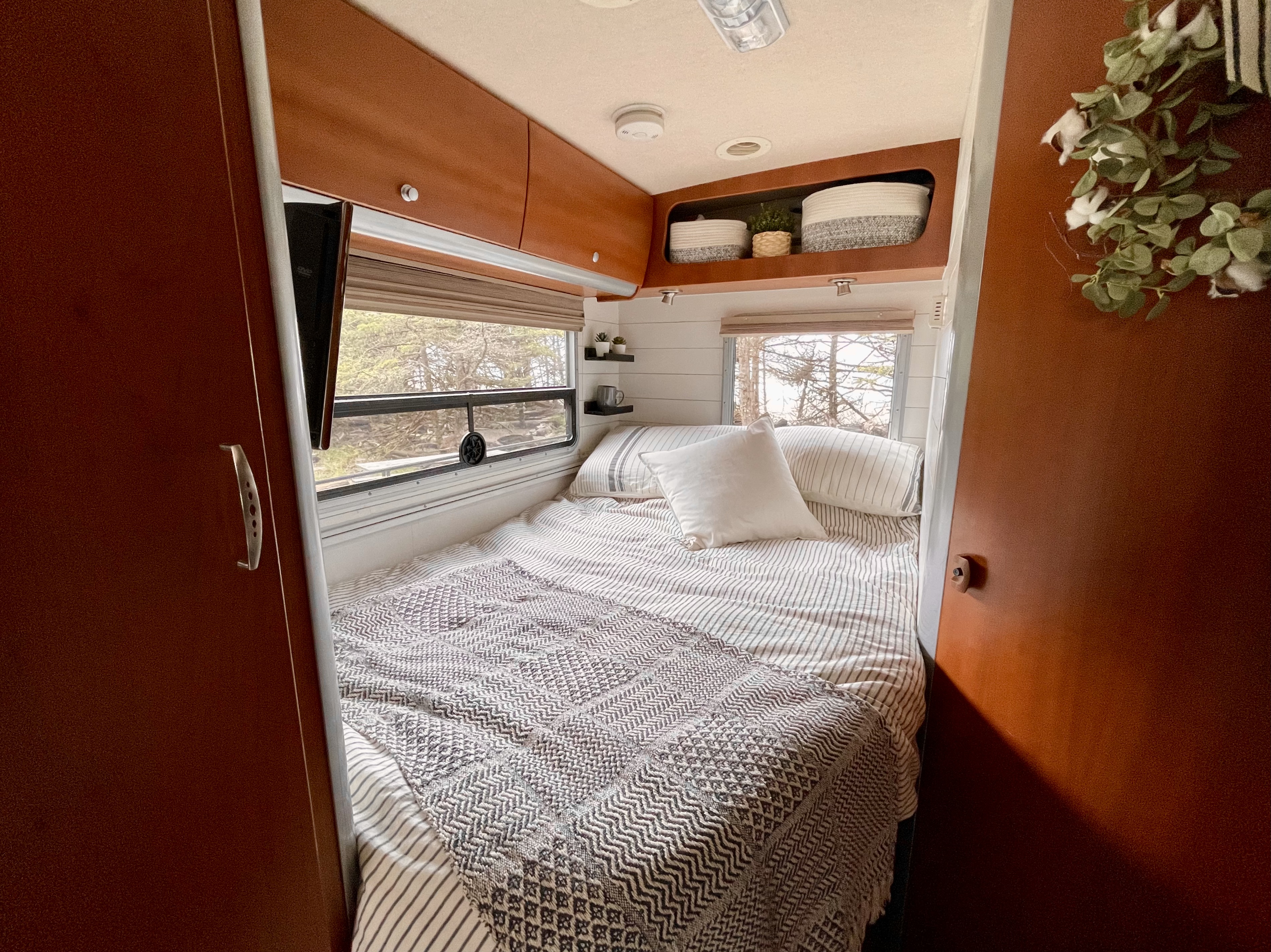 Experience comfort in this RV rental bedroom: striped bed, scenic window, & overhead storage.. Winnebago View 2006