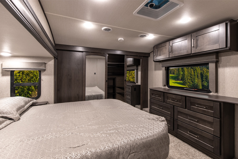 Comfortable RV bedroom interior, perfect for an rv rental. Enjoy ample storage, a large bed, and scenic window views.. Grand Design Reflection 2021