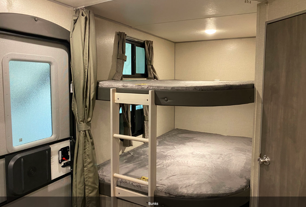 Inside an RV rental: two comfy bunk beds with grey mattresses, perfect for family adventures.. Forest River Coachmen Catalina Legacy 2022