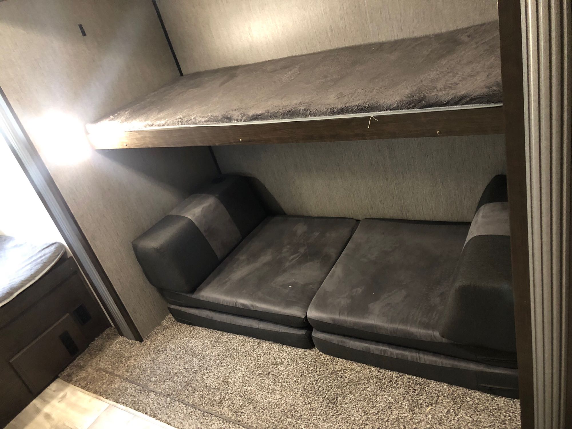 RV rental interior featuring a top bunk bed and a lower sofa that unfolds into an additional sleeping area.. Heartland Prowler 2020
