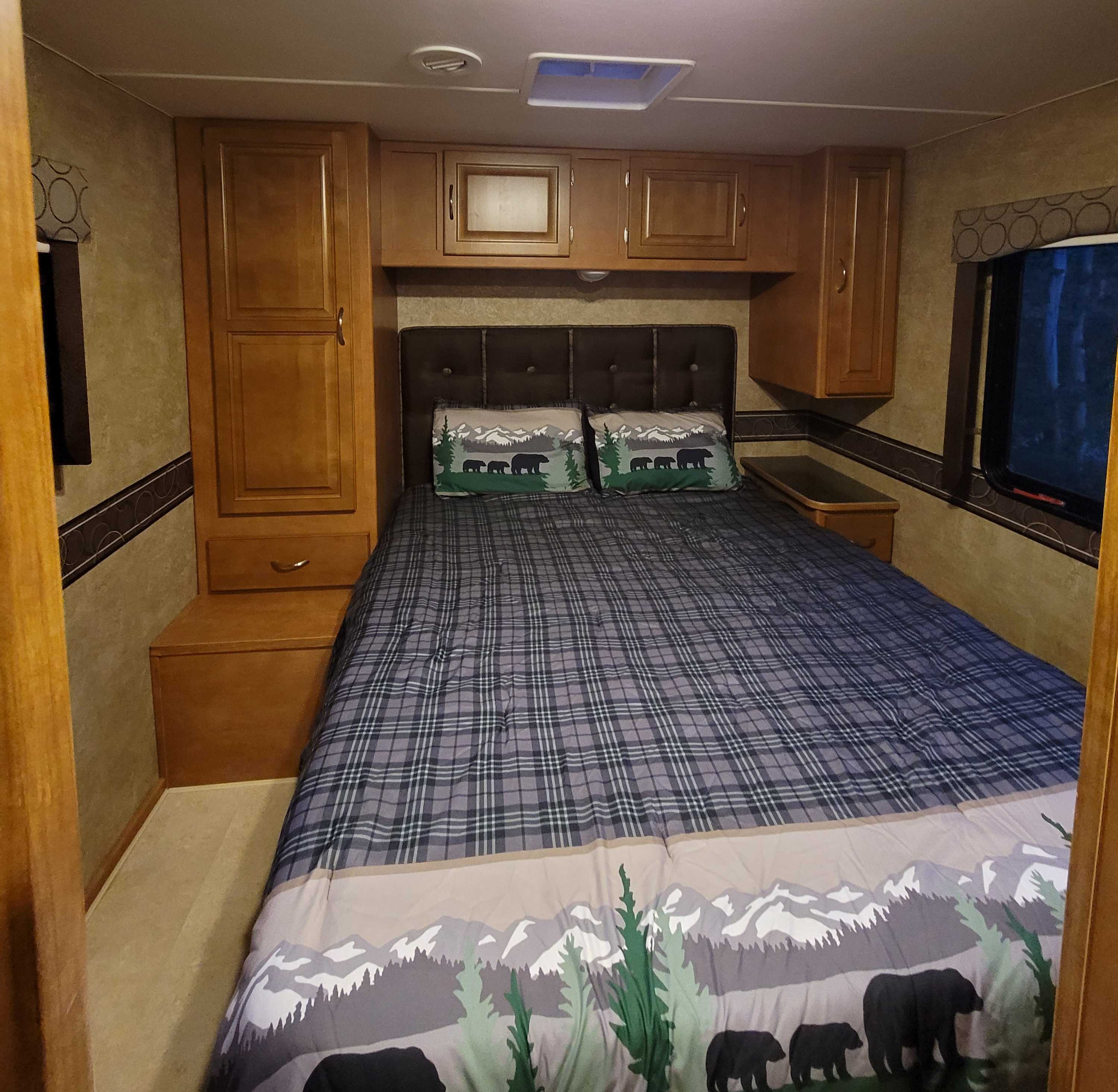 RV rental bedroom interior: Features a cozy bed with a bear-themed comforter, wood cabinetry, and a compact design.. Winnebago Minnie Winnie 2015