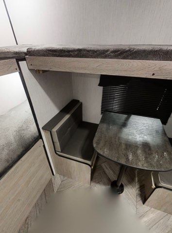 Cozy RV rental interior with bunk beds, a dinette booth, and table, perfect for family adventures.. Heartland Prowler 2022