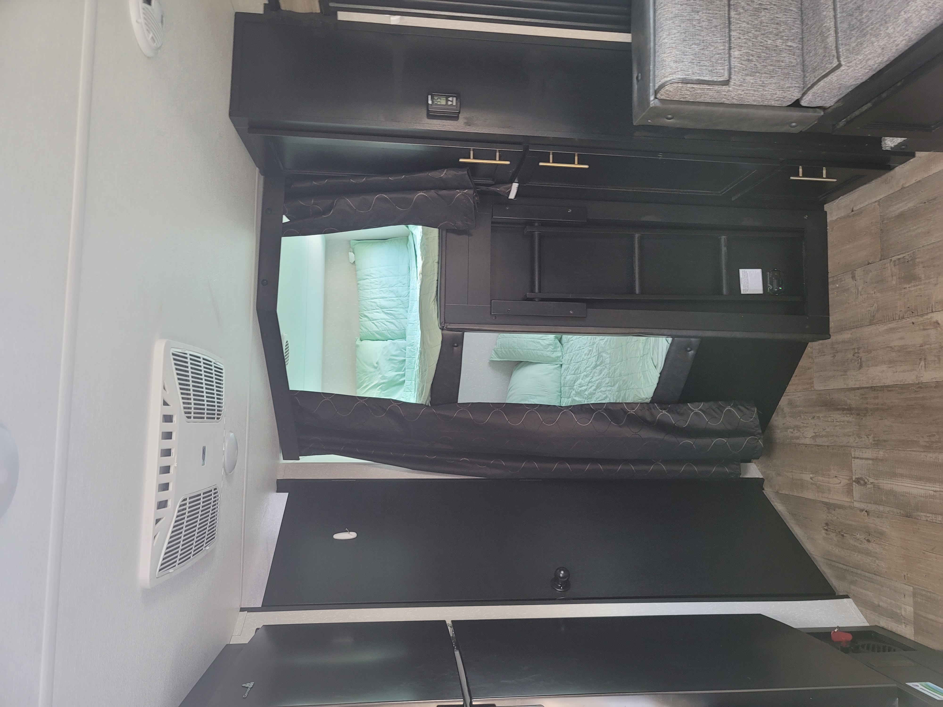 Experience comfort in this modern rv rental! Features include cozy light green bunk beds, AC, and an intuitive control panel.. Forest River Cherokee Grey Wolf 2021