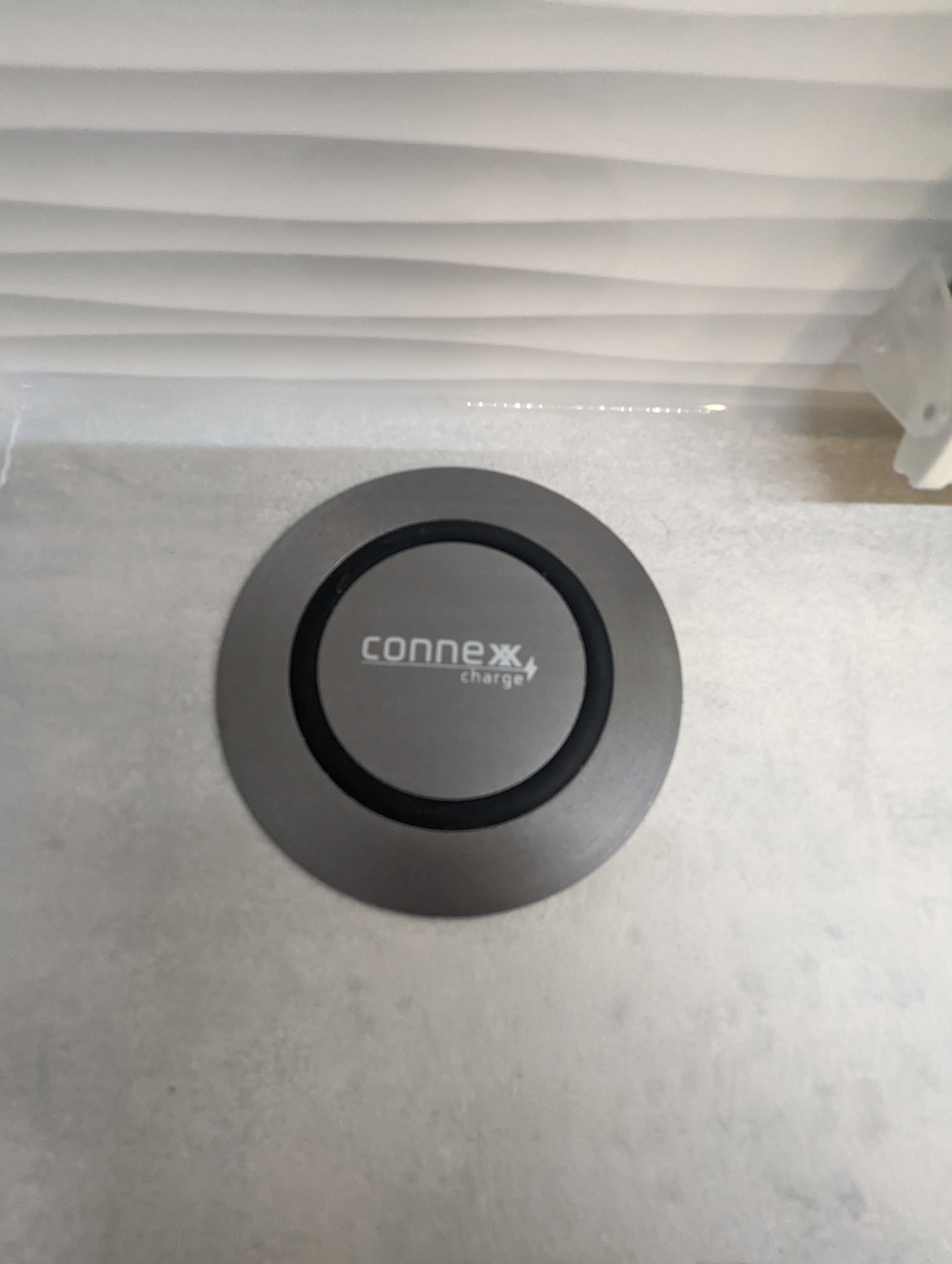 Gray ConneX charge wireless charger, often found in a modern rv rental or camper for convenient device charging.. Winnebago Hike 2022
