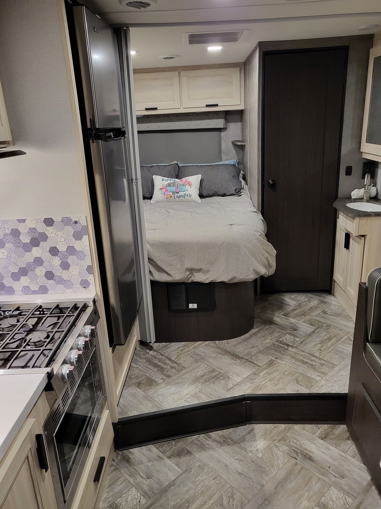 Spacious RV rental interior featuring kitchen, cozy bedroom, bathroom vanity, and stylish flooring.. Forest River Sunseeker LE 2022