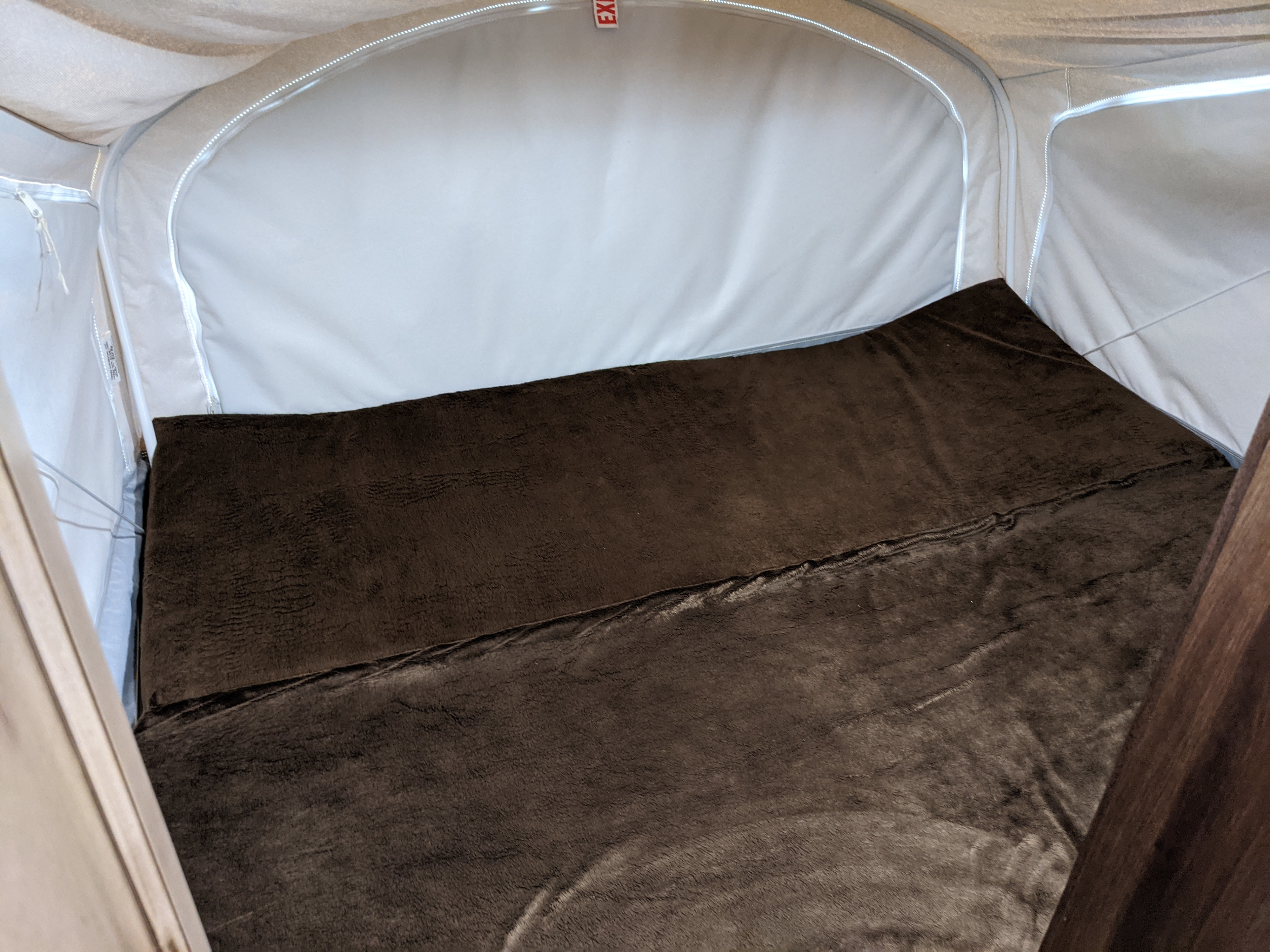 Spacious RV rental sleeping area with a soft, brown bed inside a pop-up camper. Ideal for your next trip!. Jayco Jay Feather 2019