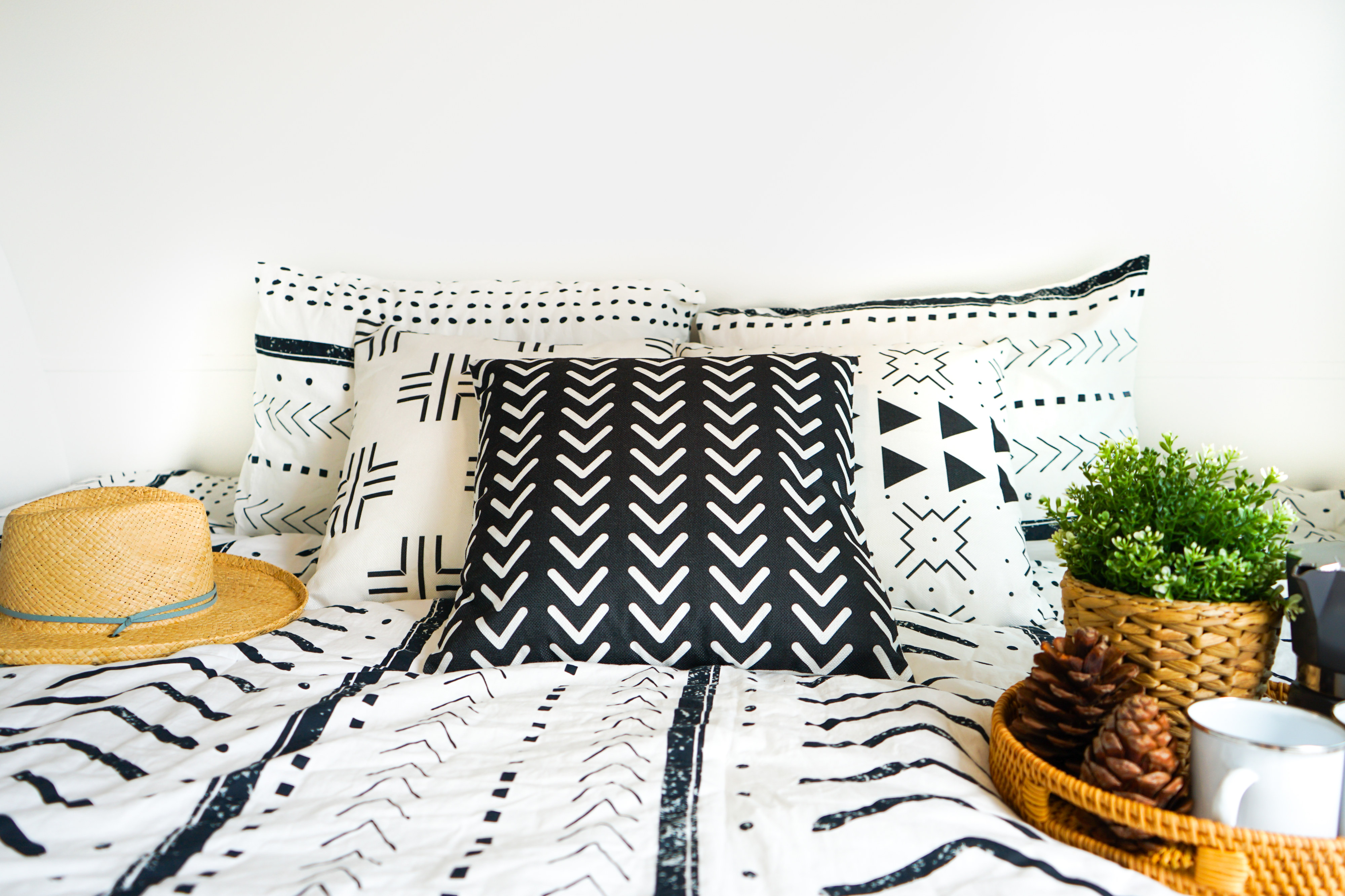 Cozy RV rental bedroom: black & white patterned bedding, pillows, straw hat, and breakfast tray.. Forest River Sonoma BH1670 2020