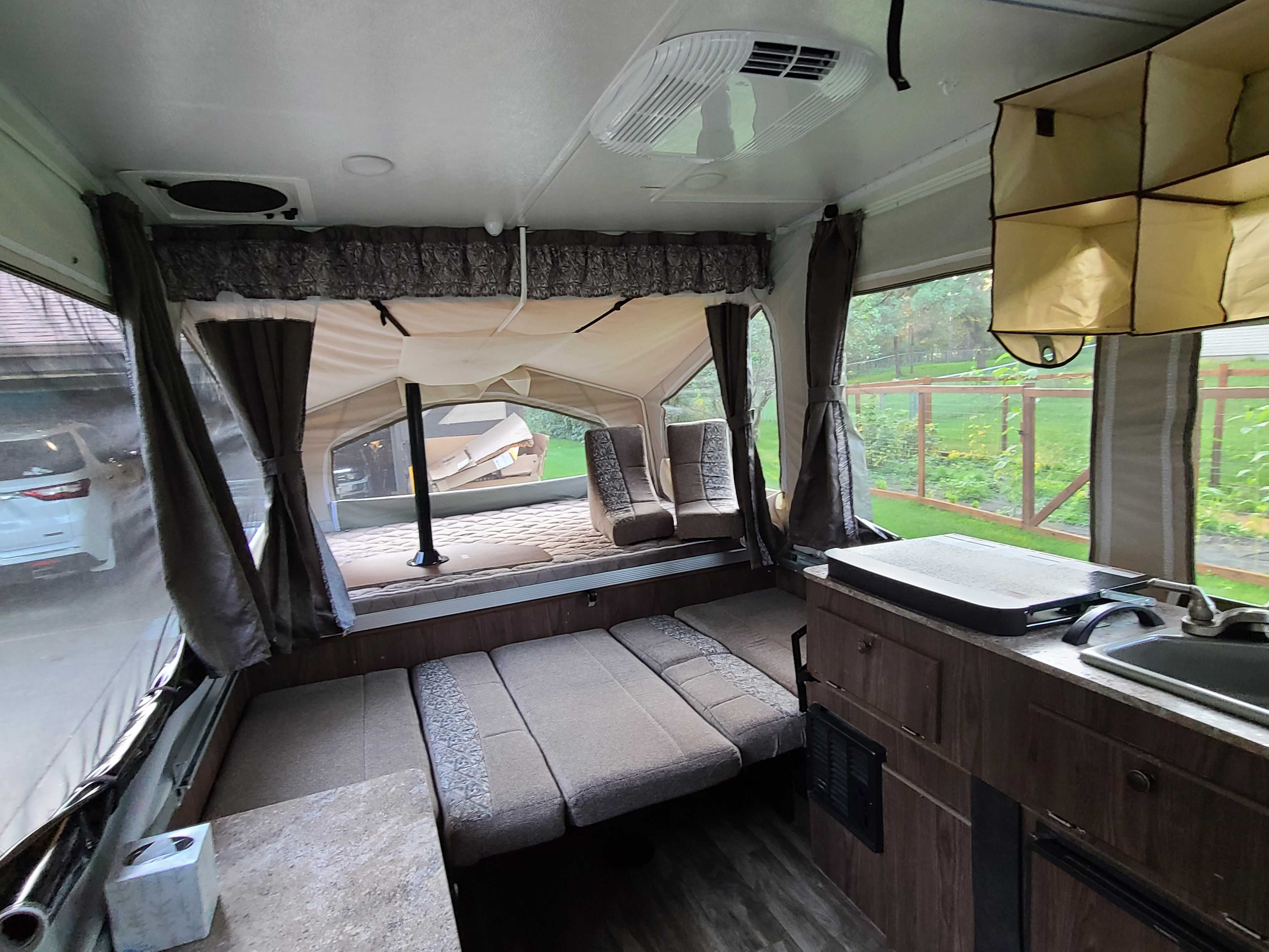RV rental interior features a pop-out bed, convertible seating, a kitchen with sink, and ceiling AC/fan units.. Forest River Flagstaff M.A.C. 2019
