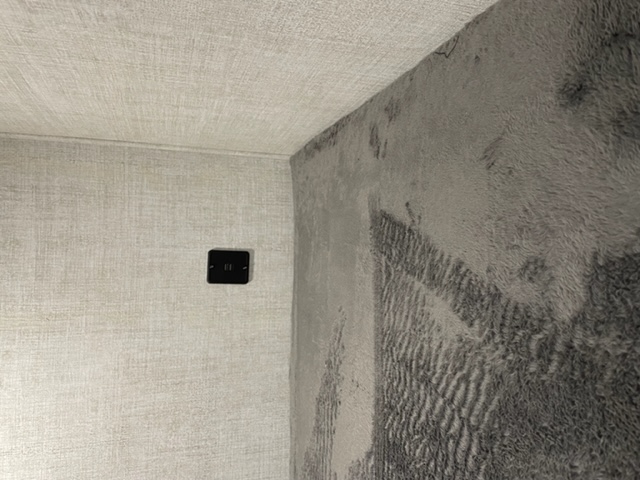 Cozy RV rental interior. Light textured walls meet a dark, fluffy wall/blanket. A small control panel is on the left wall.. Gulf Stream Amerilite 279BH 2021