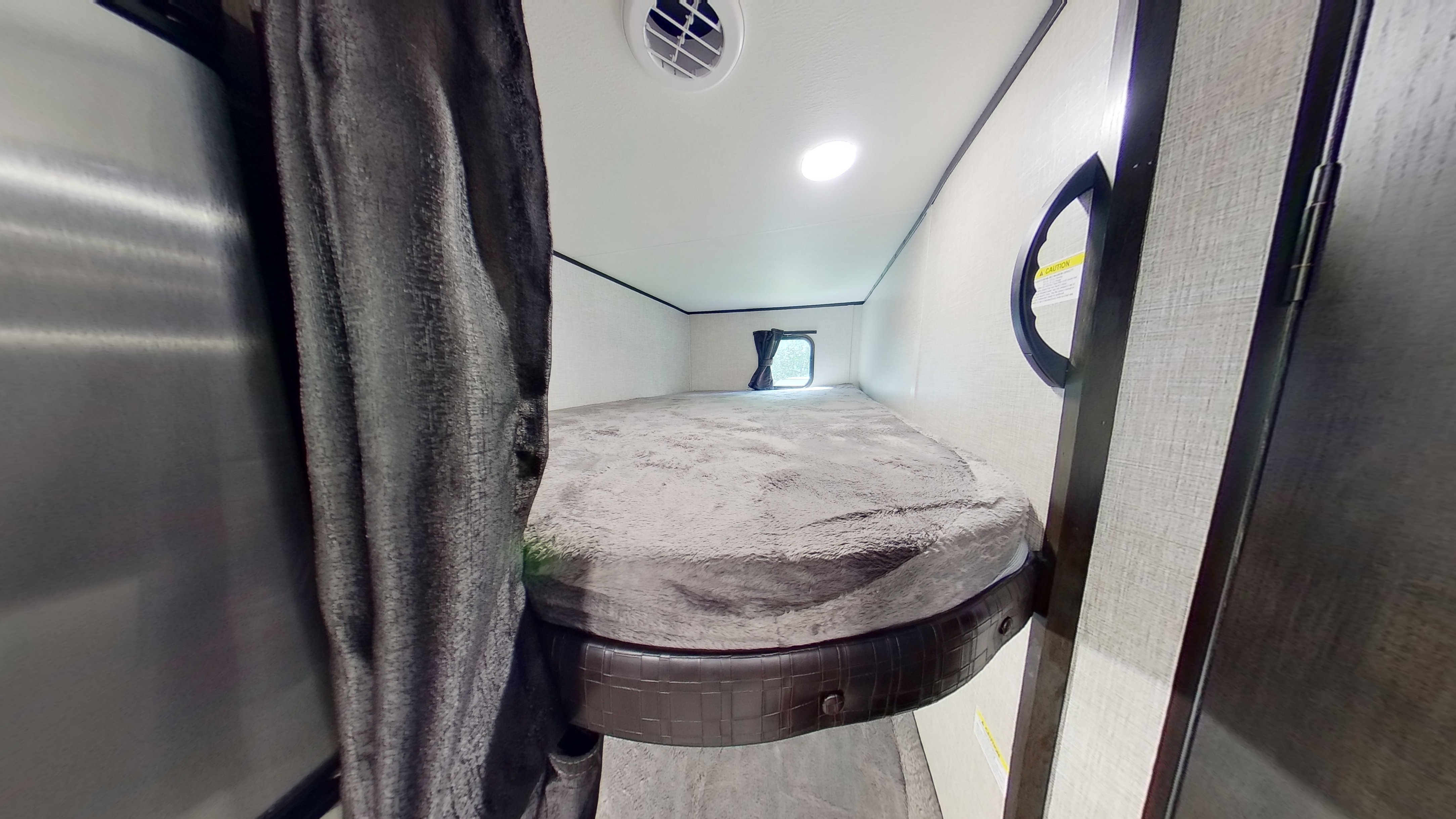 RV rental: Inside a cozy bunk bed area with soft grey bedding, a window, and overhead light, ideal for camper trips.. Jayco Jay Flight 2022