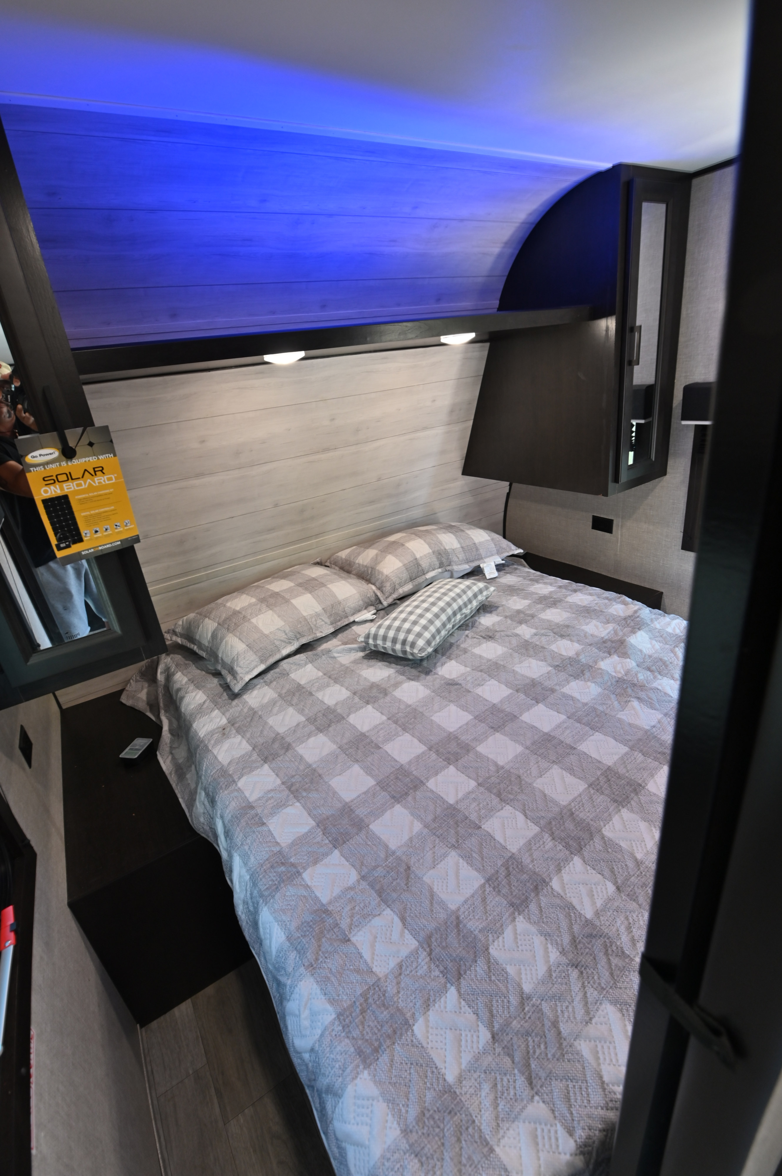 Inside a modern rv rental bedroom: a comfortable plaid bed, ambient blue lighting, and practical storage solutions.. Jayco Jay Flight SLX Rocky Mountain Edition 2022