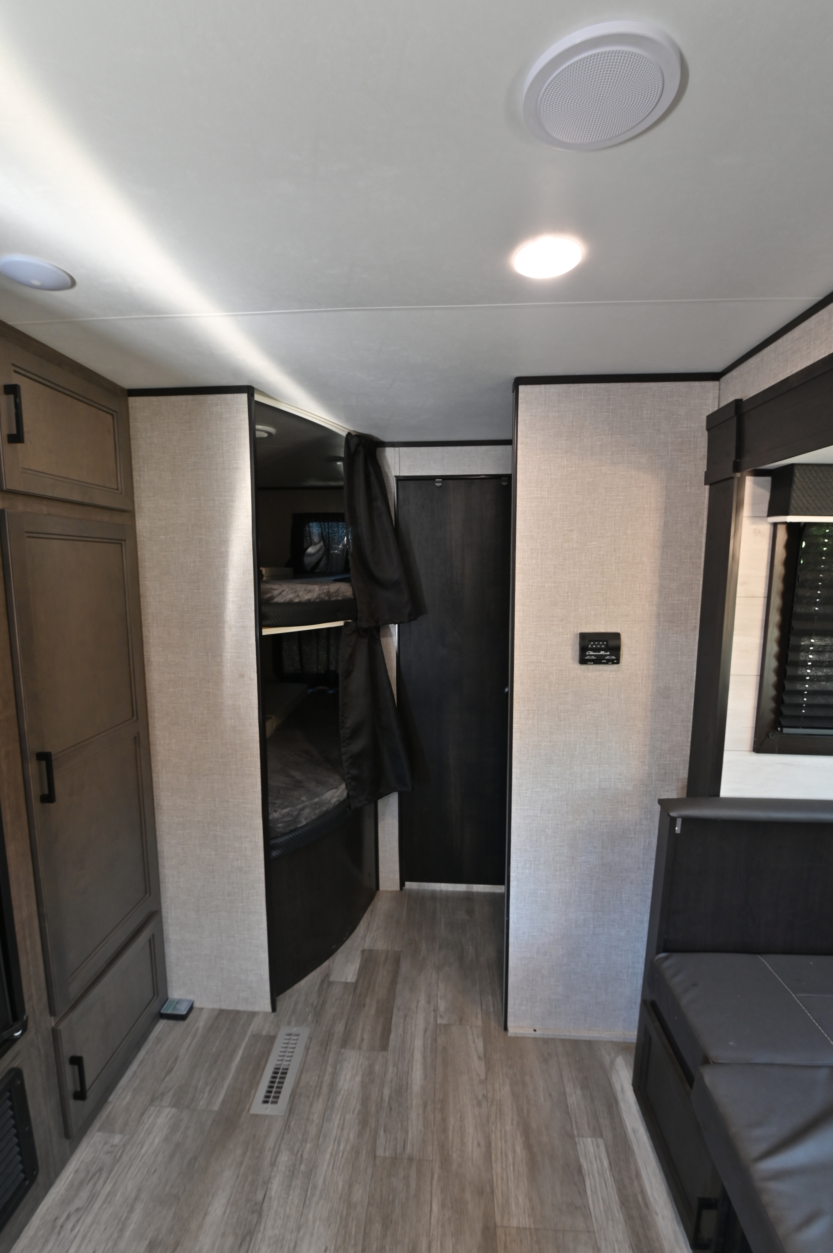 Inside an RV rental: bunk beds, control panel, and seating in a compact, organized interior with wood-look flooring.. Jayco Jay Flight SLX Rocky Mountain Edition 2022