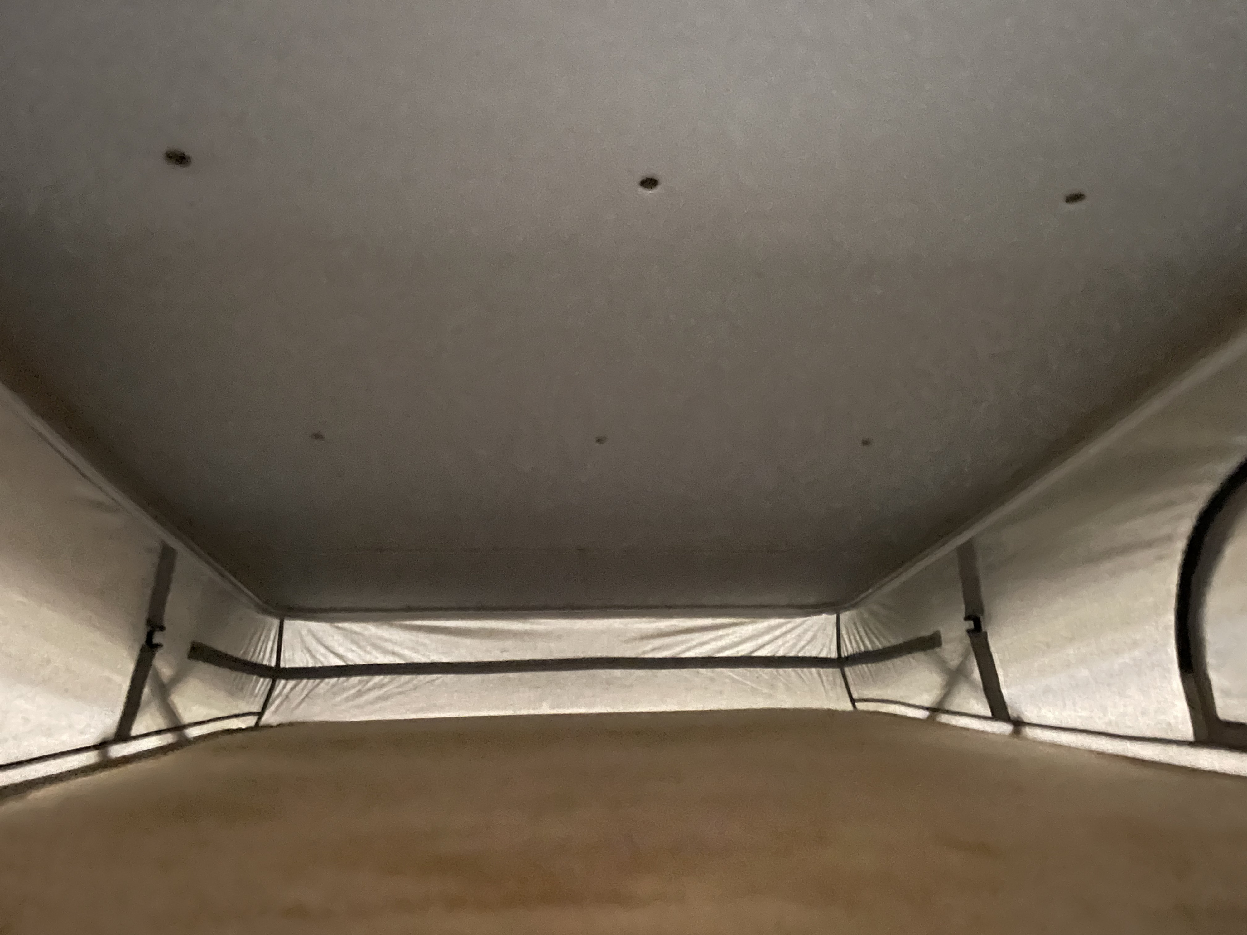 RV rental pop-top interior: looking up at the cozy bed, light fabric walls, and ceiling with subtle vents.. 2023 Thor Motor Coach Sprinter Tellaro 20j 20j 2023
