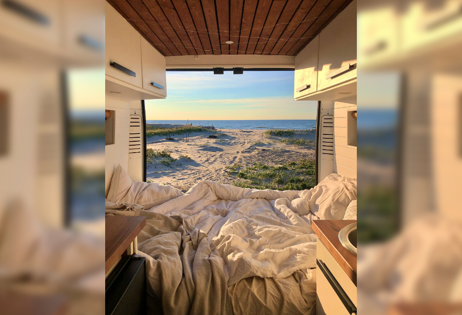 Experience van life in an RV rental: a cozy bed faces a sandy beach, dunes & ocean. Ideal for serene beach getaways.. RAM Promaster 2500 2017