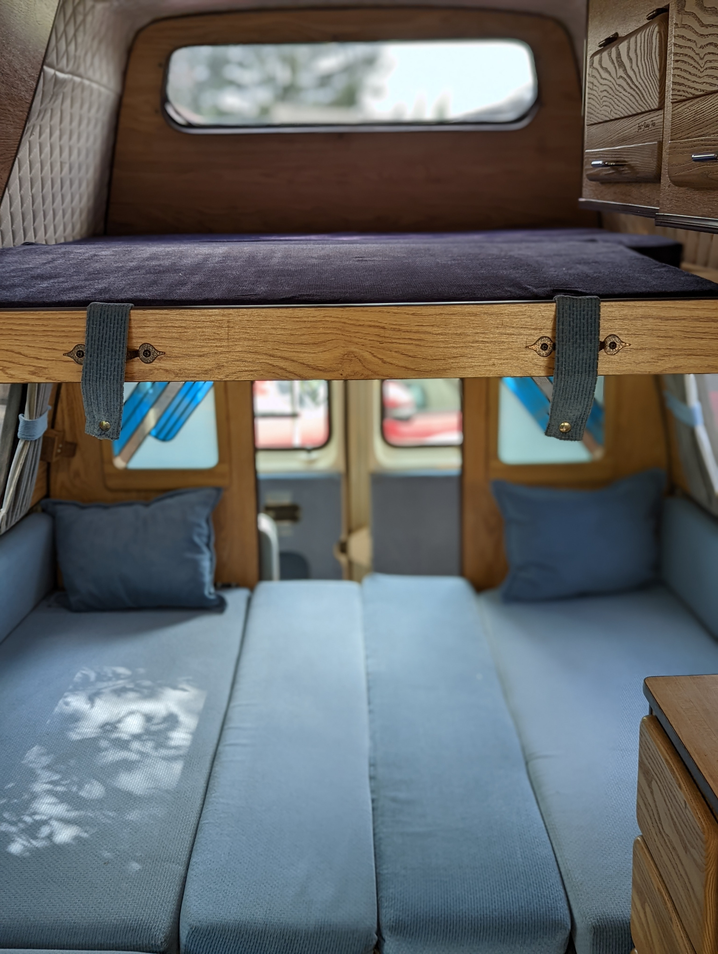 Step inside this comfortable RV rental. Features include a bunk bed, lower seating/sleeping area, and wooden accents, ready for your next adventure.. Ford Econoline 1988