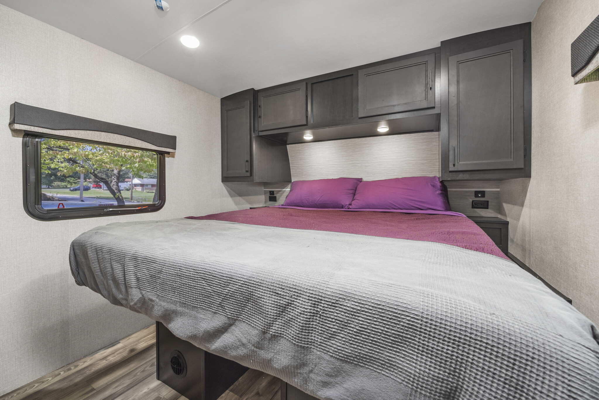 Cozy RV rental bedroom with a comfortable bed, ample storage, and scenic window views, ideal for travel.. Highland Ridge RV Open Range Light 2022