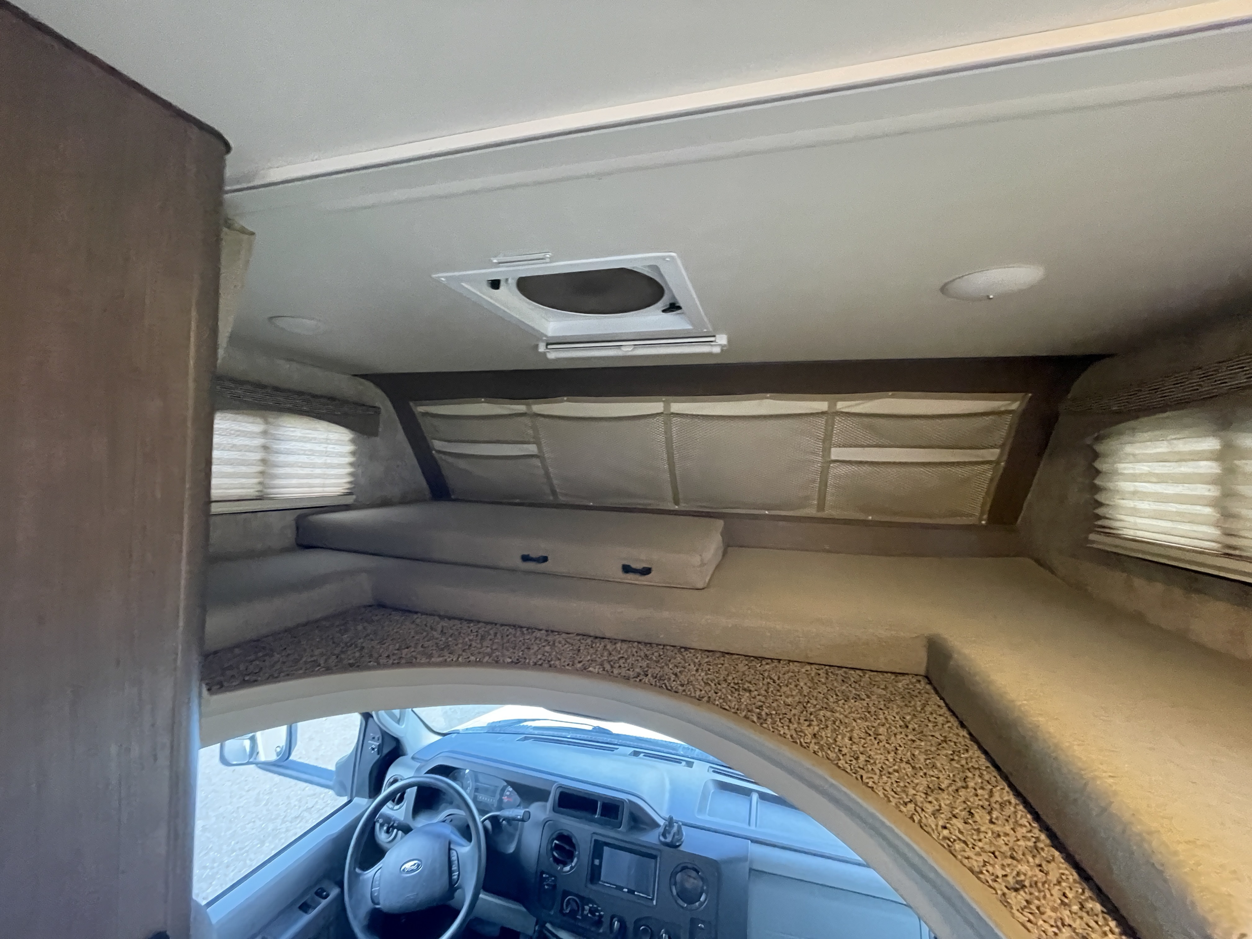 Spacious RV rental cab-over bunk bed with convenient storage and ceiling vent.. Alp Adventurer 19RD 2019