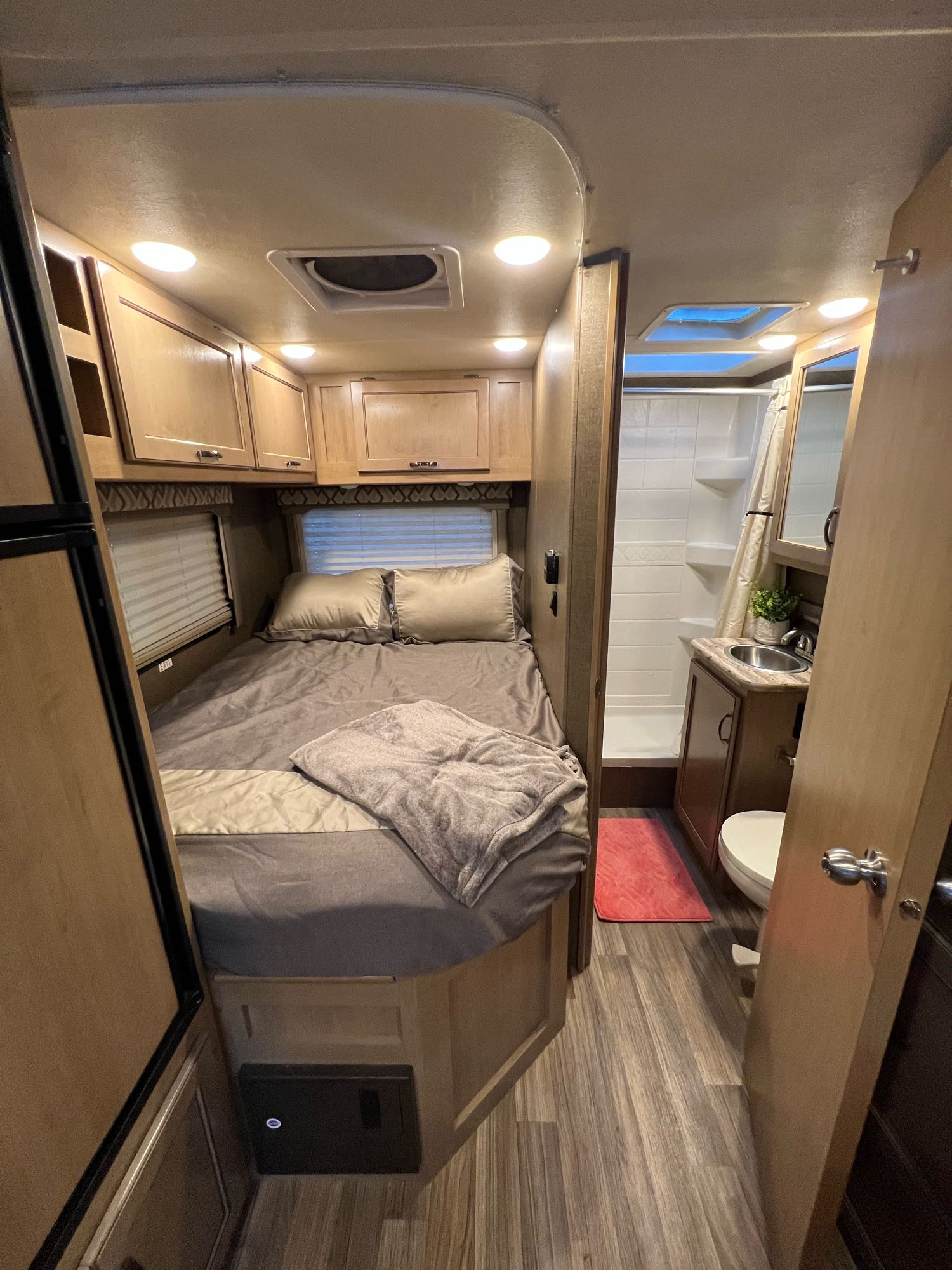 Explore this comfy RV rental interior: bedroom with overhead storage, compact bathroom, and skylight. Ready for road trips!. Thor Motor Coach Chateau 2019