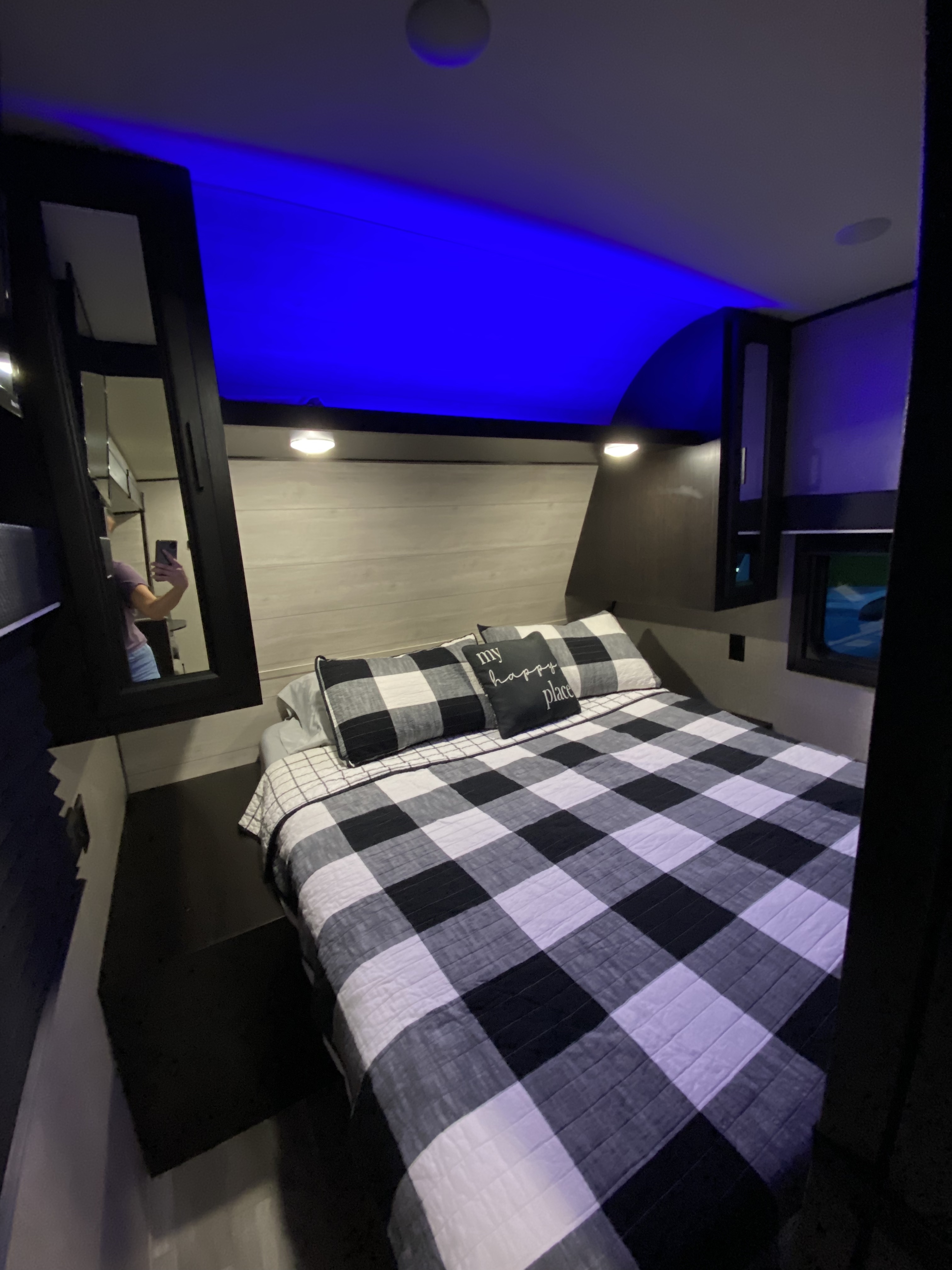 RV rental bedroom: a cozy retreat with blue LED ceiling lights and black-and-white plaid bedding.. Jayco Jay Flight SLX 2022