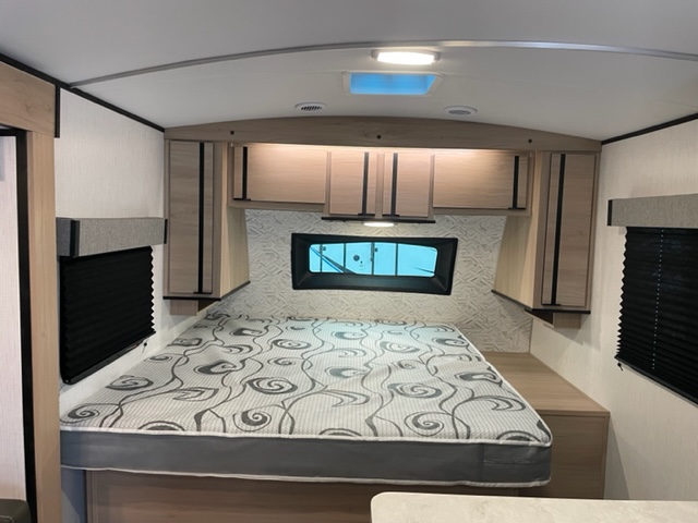Bright RV rental bedroom: comfy bed, ample overhead cabinets, and windows with privacy blinds.. Cruiser Rv Corp Radiance 2022
