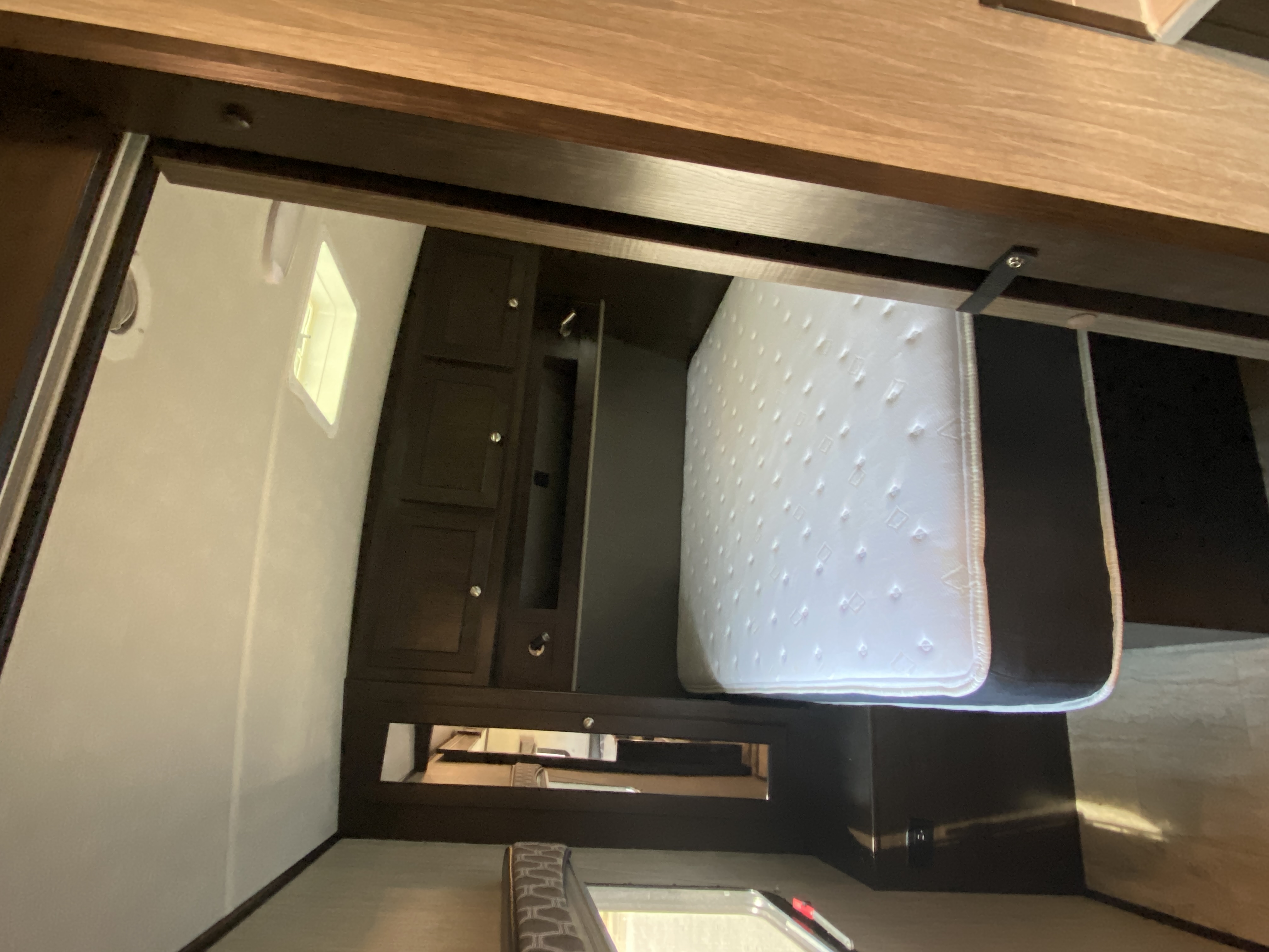 Inside an RV rental: A compact bedroom with a white mattress & dark wood cabinets.. Cruiser Shadow 277BHS 2020