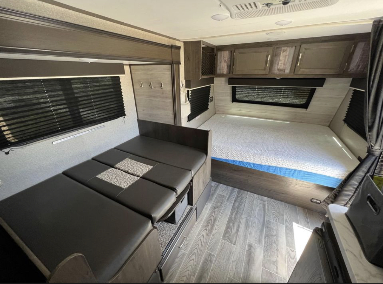 Explore this versatile **rv rental** interior featuring a comfortable bed and adaptable dinette seating, ideal for your next camper adventure.. Jayco Jay Flight SLX Baja Edition 2021