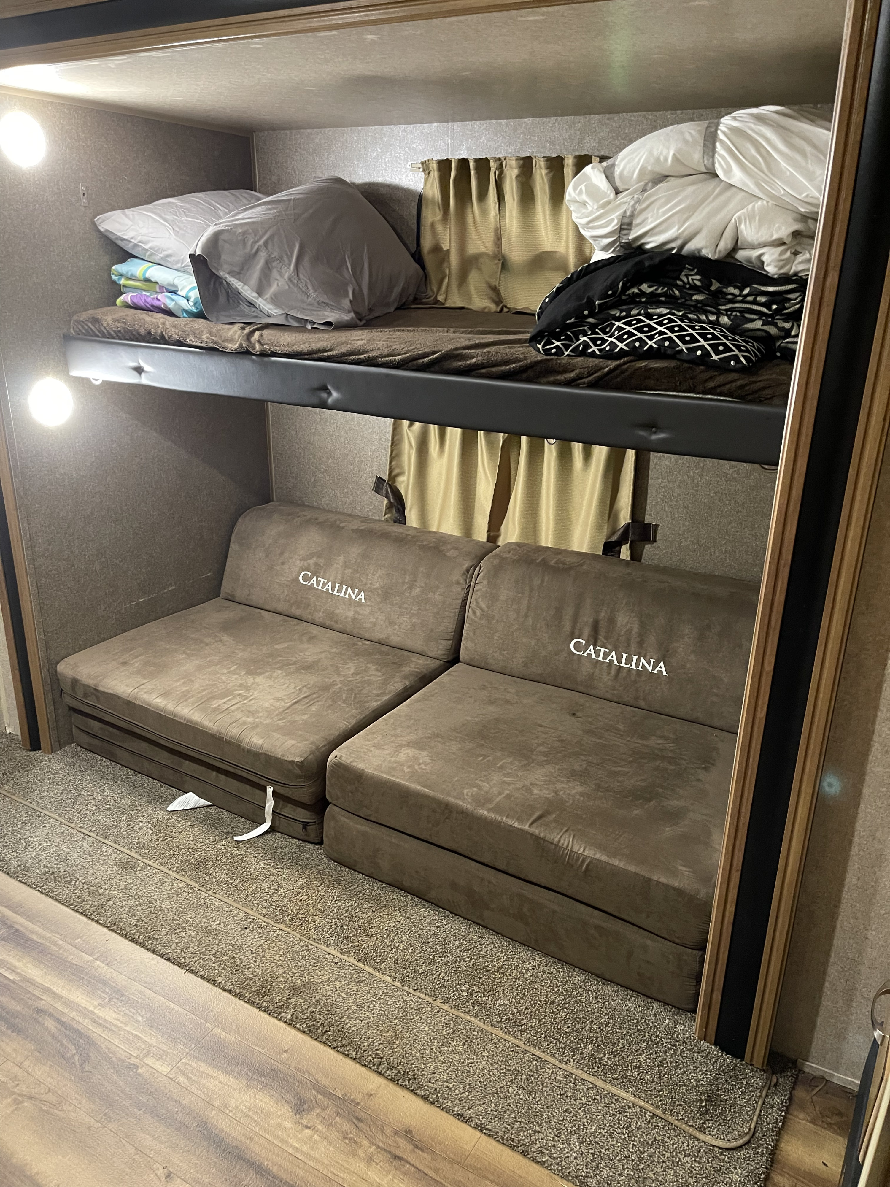 Inside an RV rental: upper bunk bed & lower convertible Catalina sofa sections for sleeping/seating.. Coachmen Catalina 2019