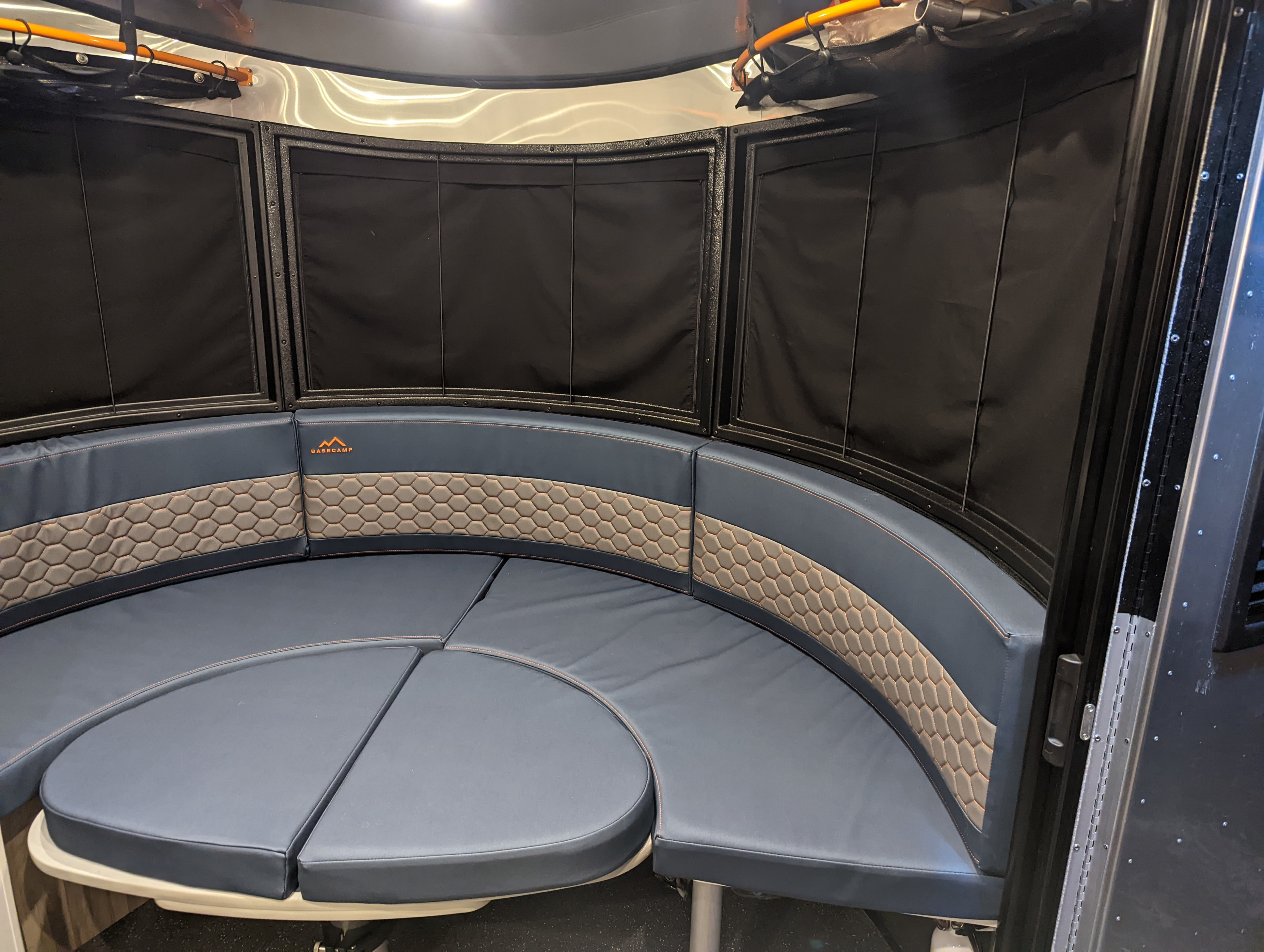 This RV rental features a comfortable Airstream Basecamp interior with a curved dinette, hexagonal cushions, and window shades.. Airstream Basecamp 2022