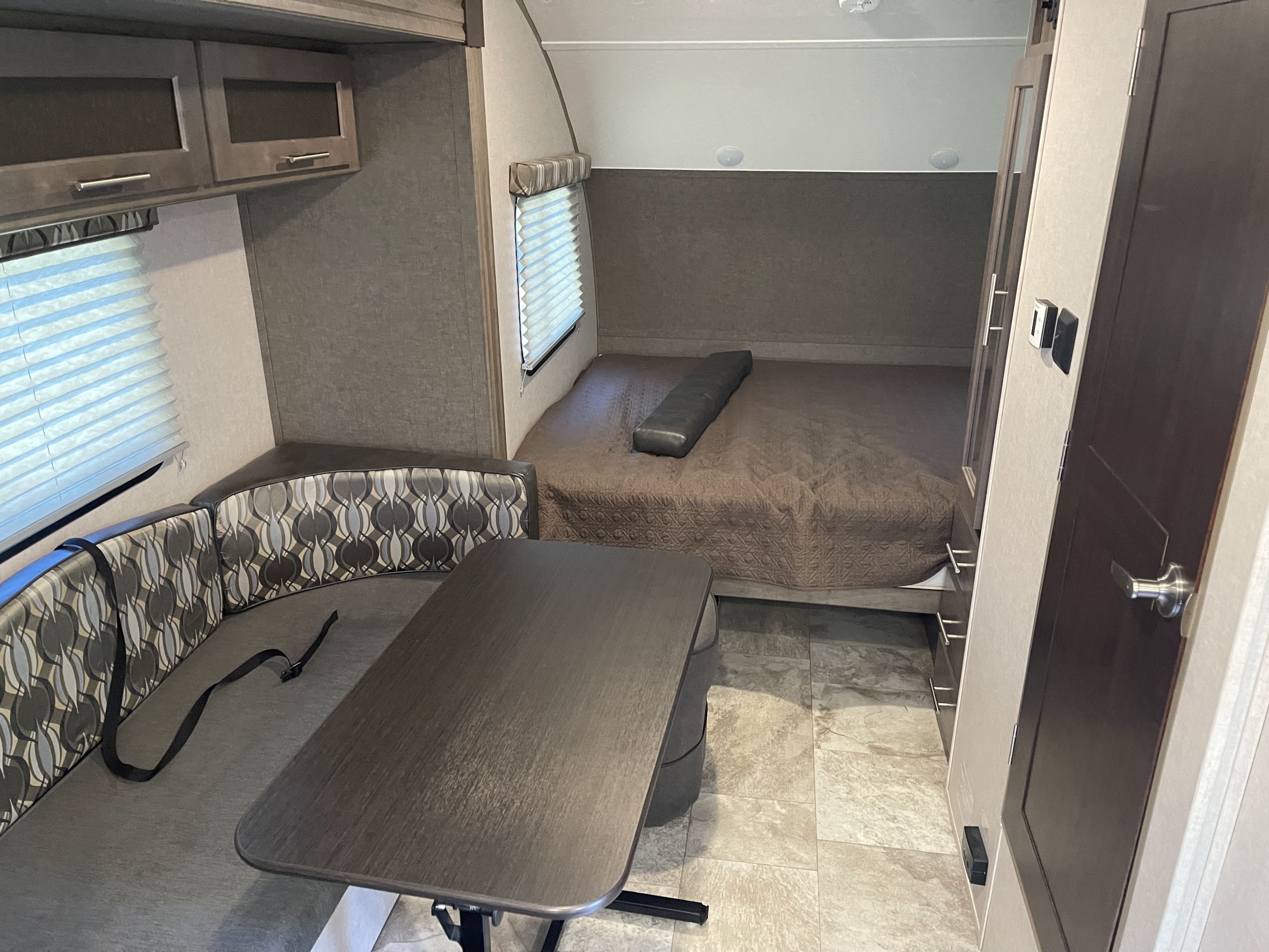 RV rental interior features a compact living space with a bed, dinette, and overhead cabinets for comfortable travel.. R-Pod Hood River Edition 2018