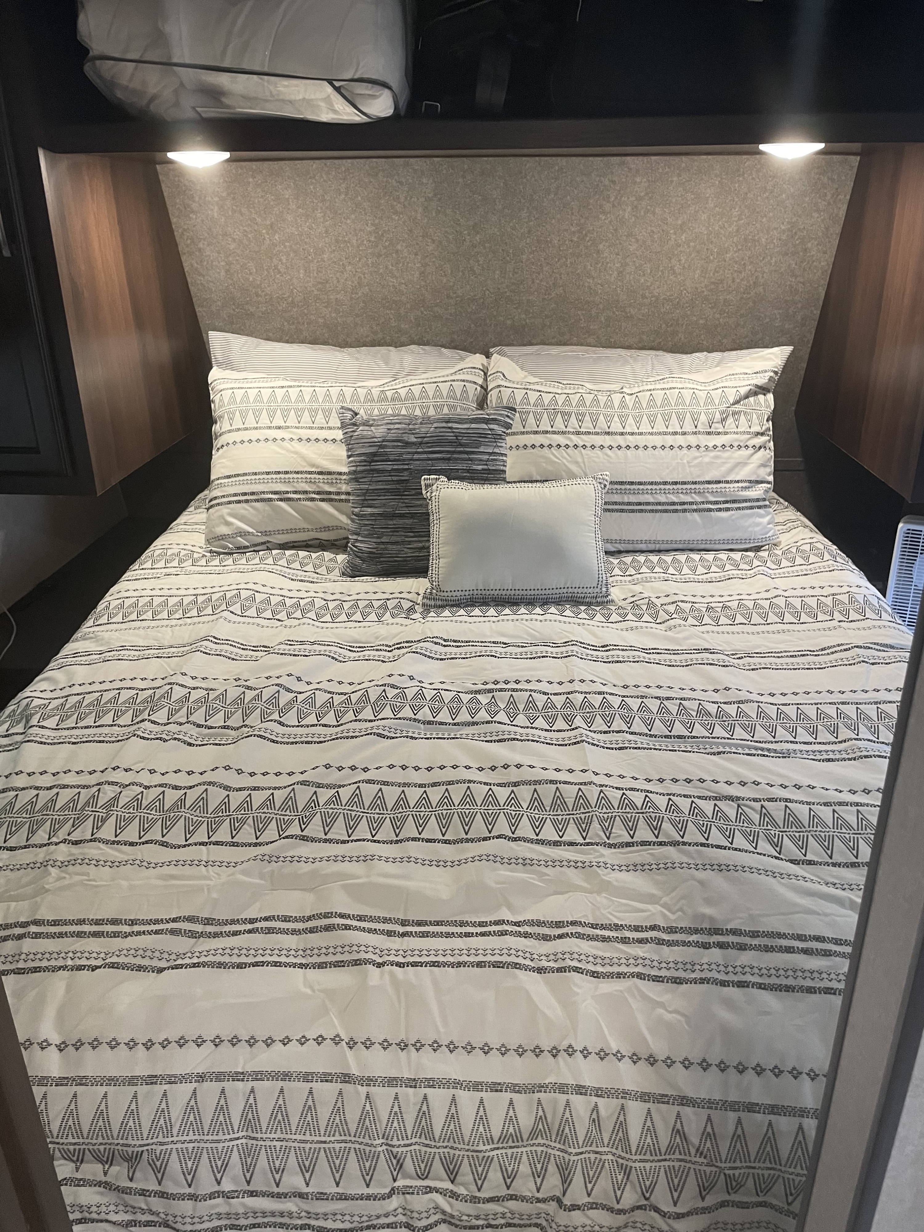 Comfortable RV rental bedroom with white and grey patterned bedding, pillows, and built-in reading lights.. Jayco Jay Flight SLX 2020