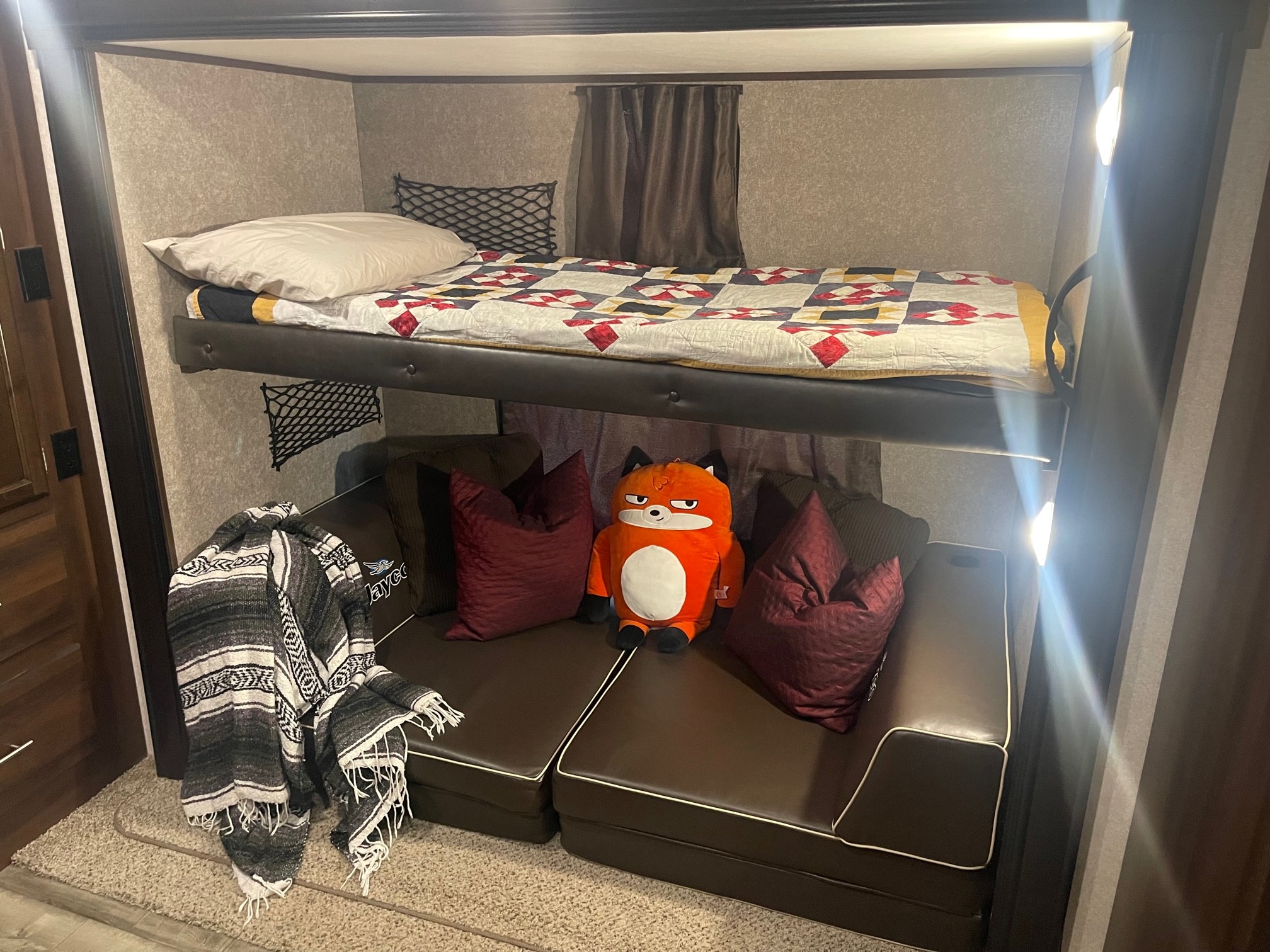 Inside a spacious RV rental bunkhouse: comfy bed, sofa, and a playful fox friend. Ideal for family trips.. Jayco Jay Flight 2019