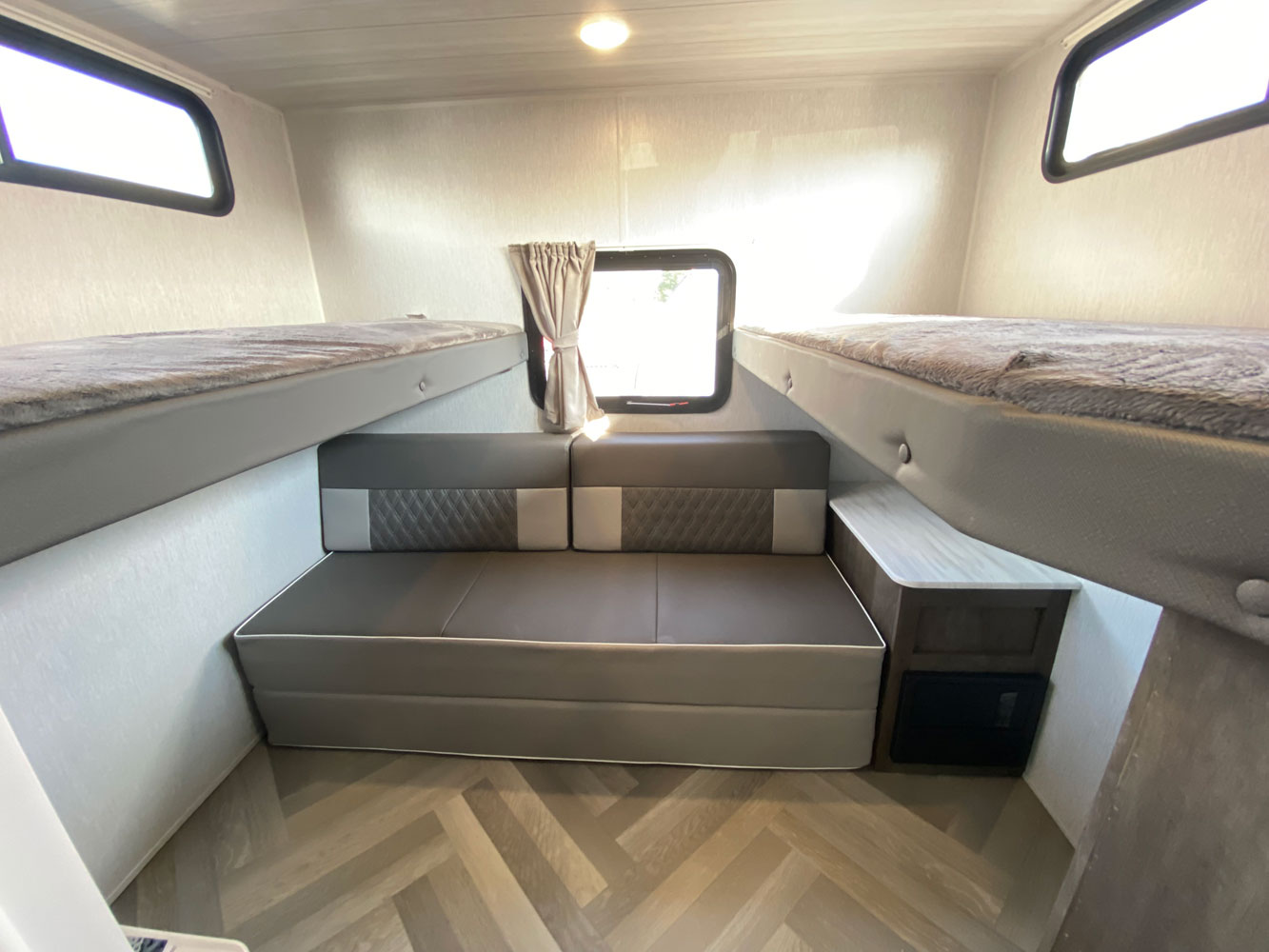 This RV rental bunk room features a convertible sofa bed and two upper bunks for versatile family sleeping.. Forest River Wildwood X-Lite 2022