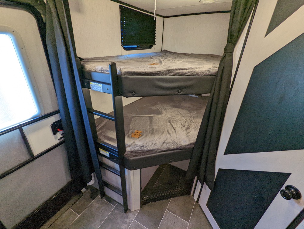 This RV rental features a cozy bunk bed sleeping area with a ladder, providing efficient space for travelers.. Heartland RVs Mallard 2022