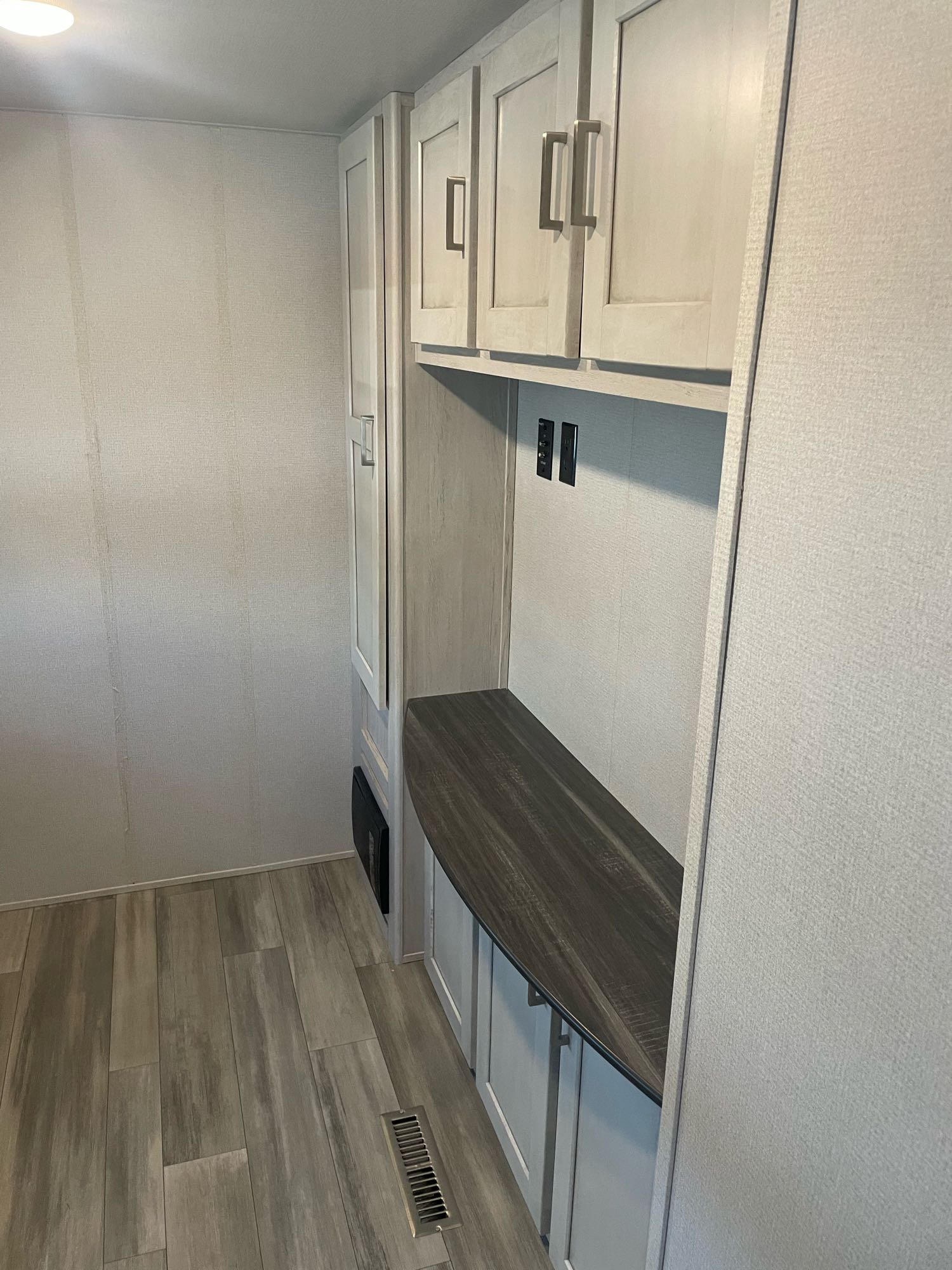 RV rental interior: light cabinets, dark counter, wood floor, and textured walls of a spacious living area.. Keystone RV Sprinter Limited 2022