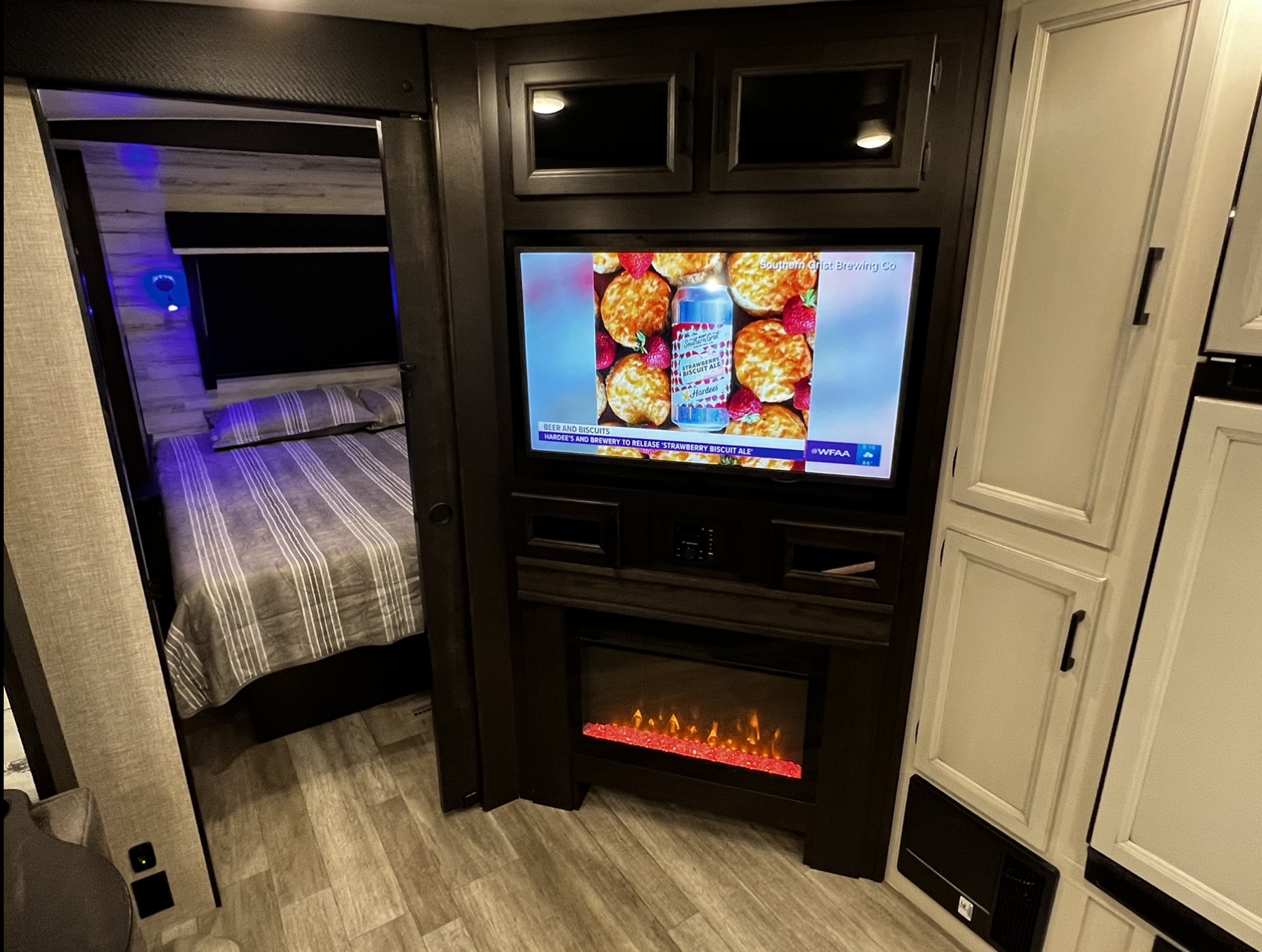 RV rental with full entertainment: TV, electric fireplace, and private bedroom with accent lights for comfort.. Jayco White Hawk 2022