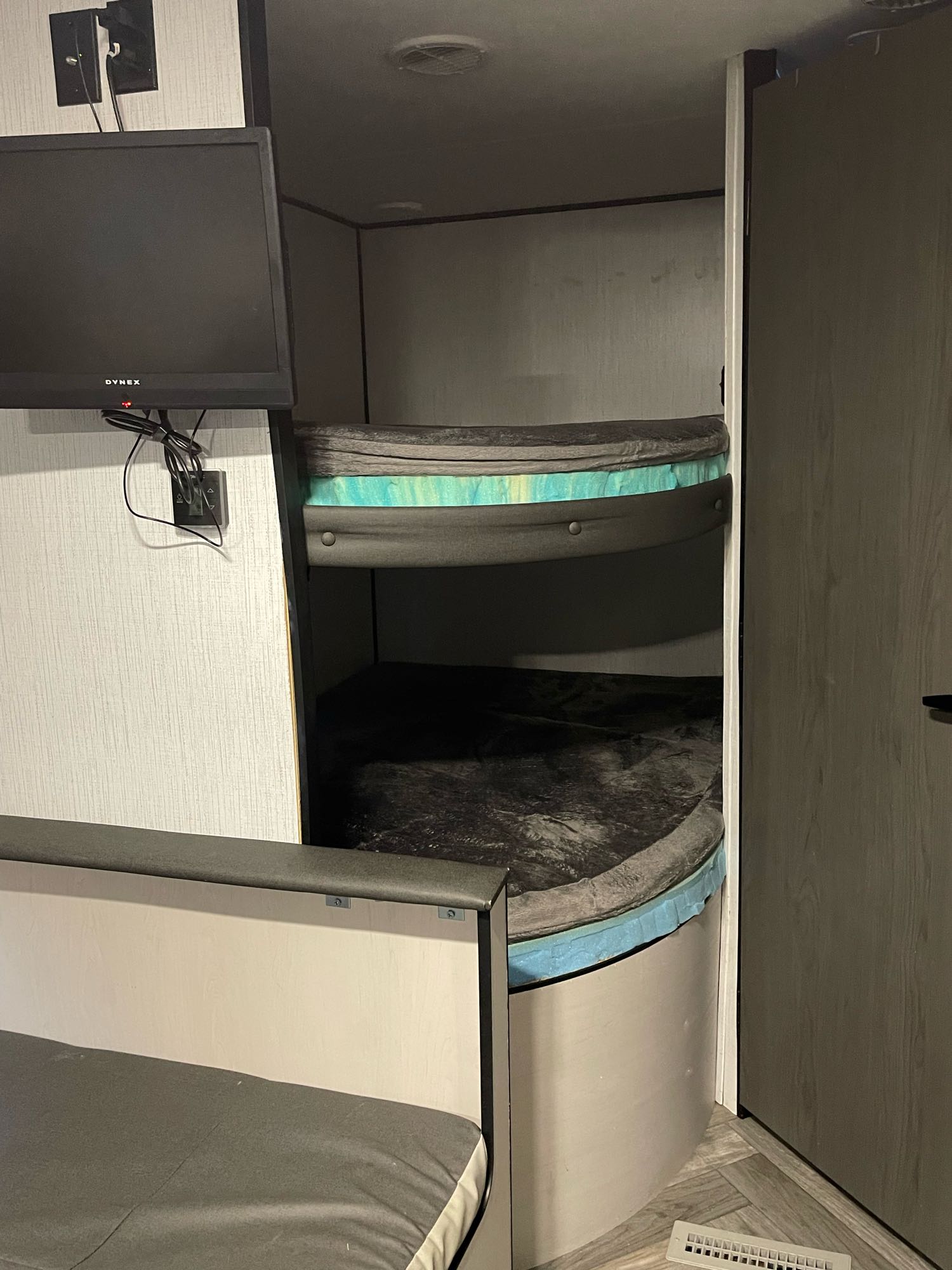 Compact RV rental interior featuring stacked bunk beds, a mounted TV, and a dinette area for cozy travel.. Heartland RVs Prowler 2021