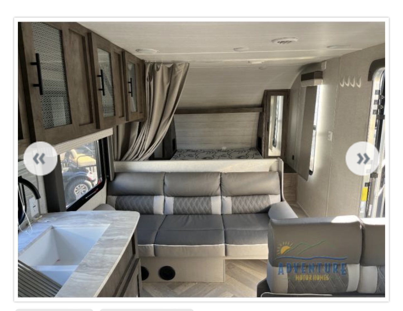 Step inside this modern RV rental: a comfortable sofa, full kitchen, and private sleeping area are ready for your adventure.. Forest River Wildwood X-Lite 2021