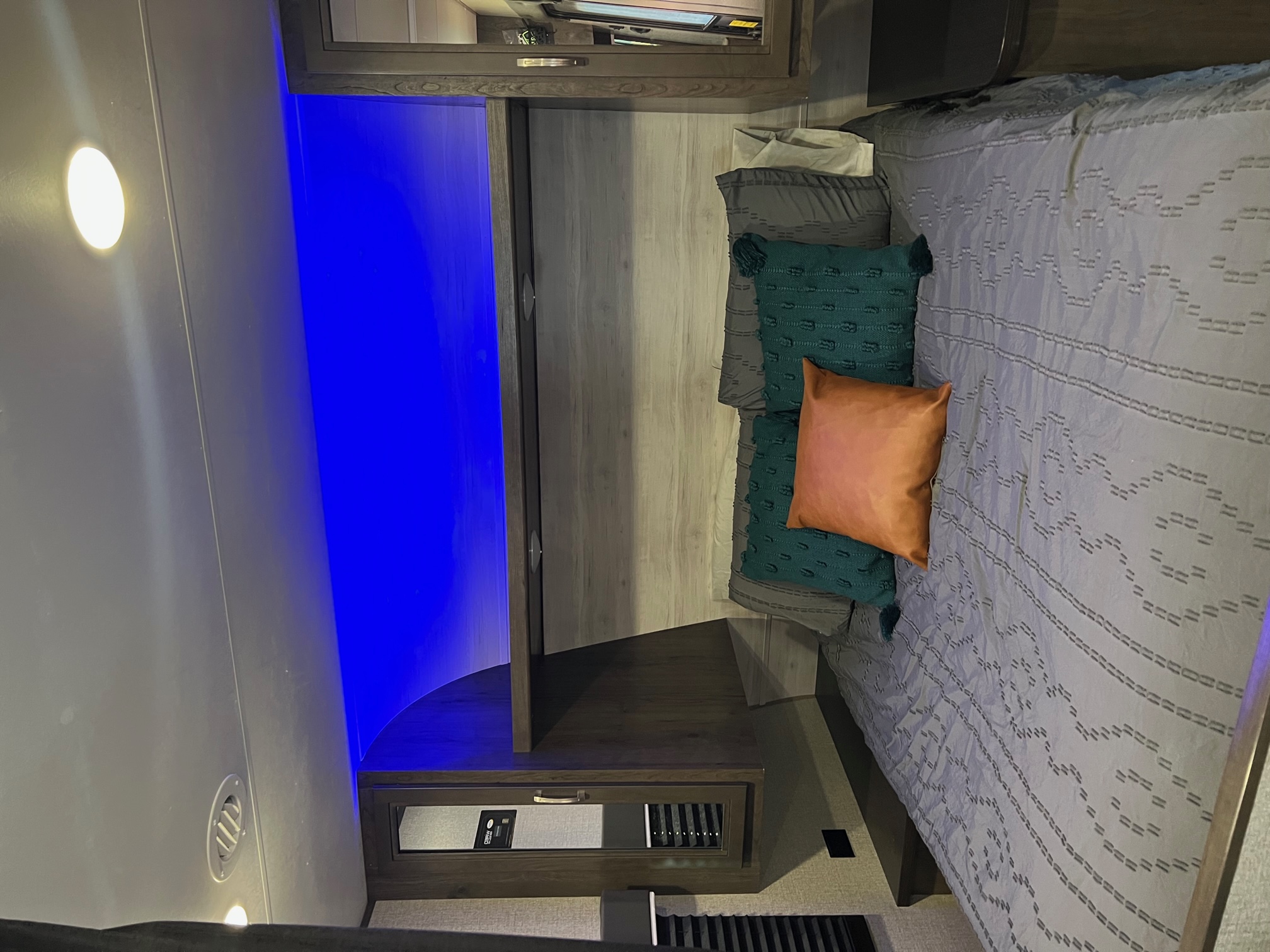 This RV rental bedroom features cozy bedding, blue accent lighting, and smart storage for travel comfort.. Jayco Jay Flight SLX Rocky Mountain Edition 2021