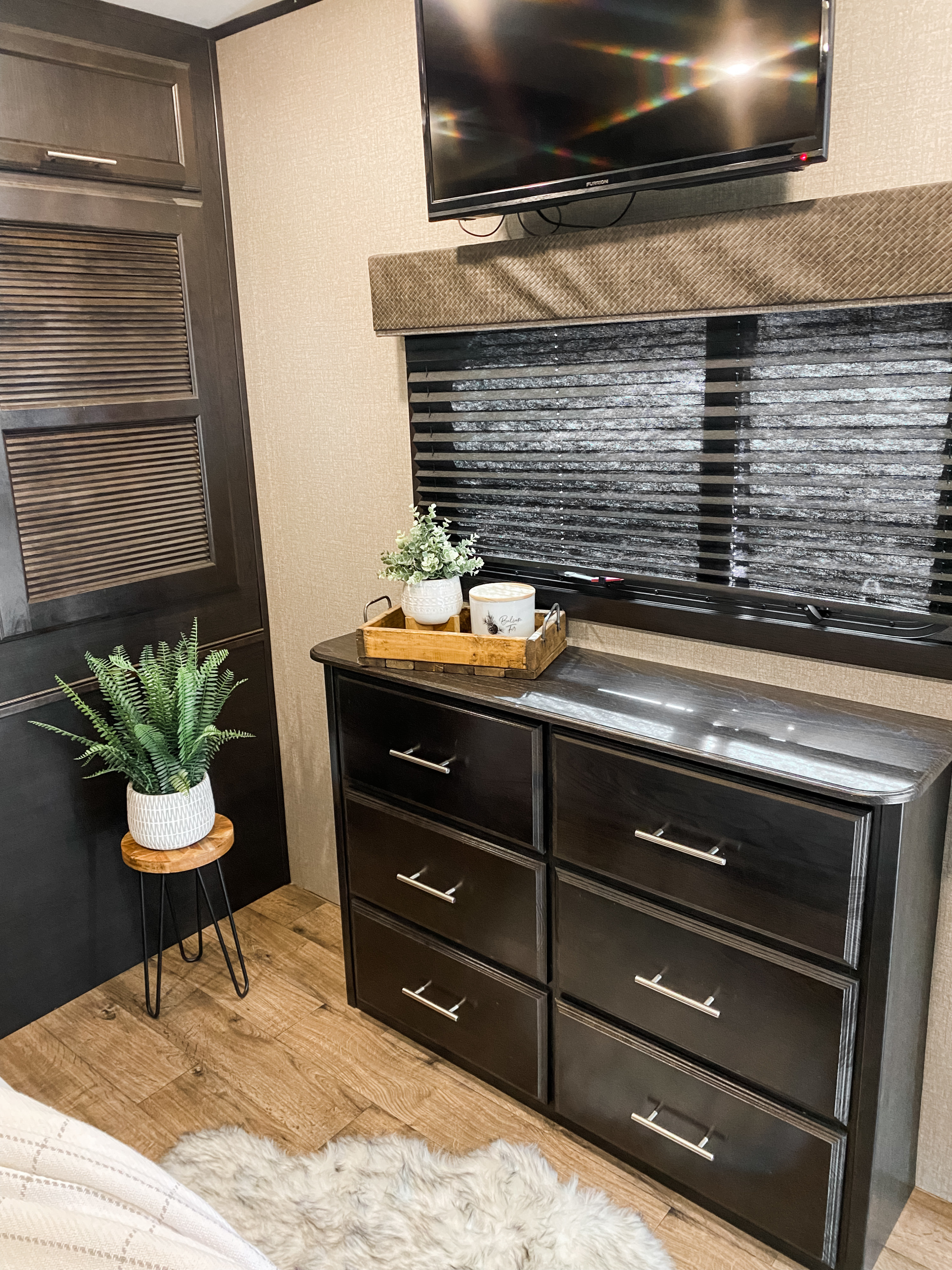 RV rental interior with modern dark dresser, TV, window blinds, and decorative plants. A comfortable and well-appointed space.. Jayco EAGLE 2020