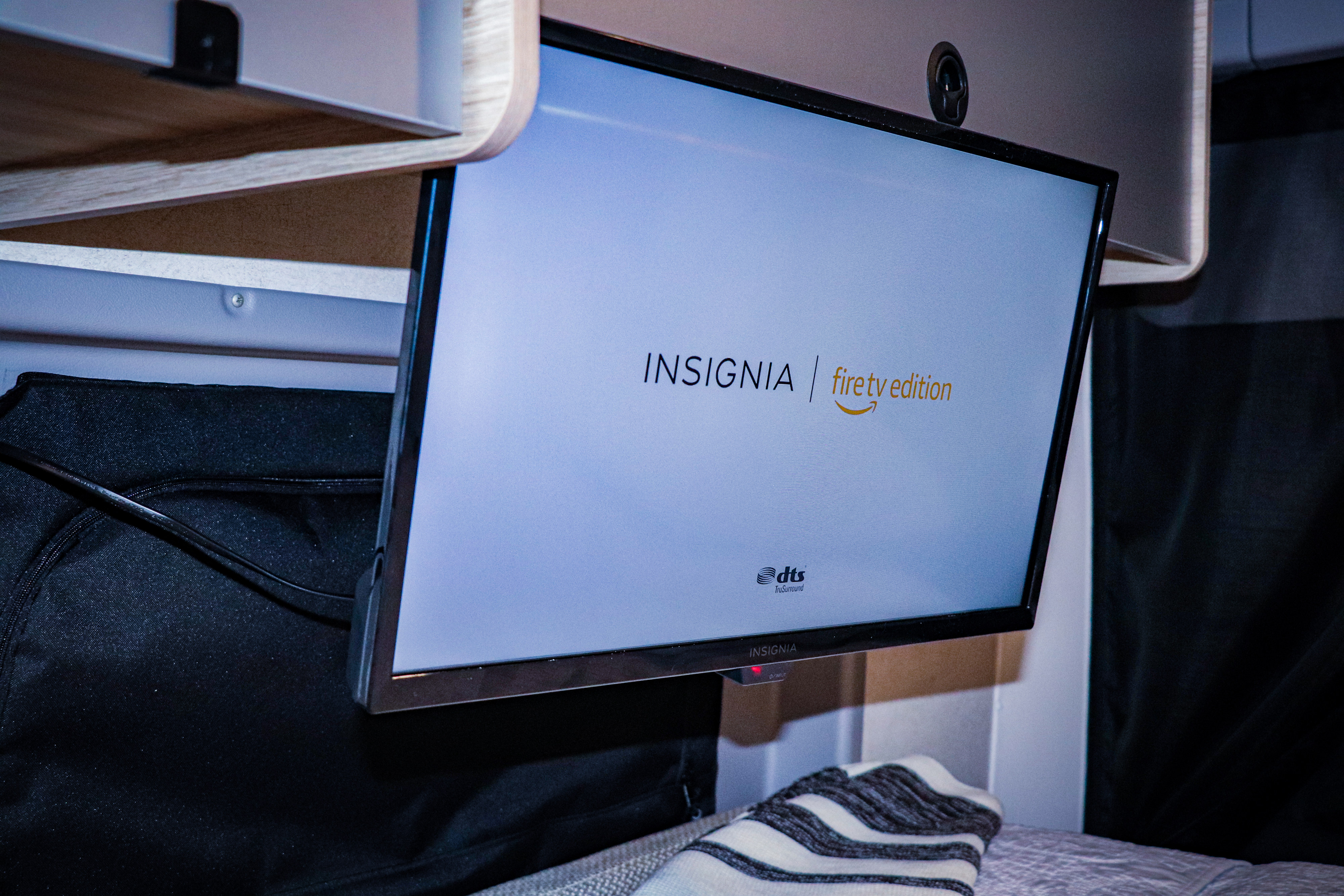 An Insignia Fire TV Edition screen powers on in a modern rv rental, displaying its logo amidst a cozy setup.. Winnebago Solis 2022