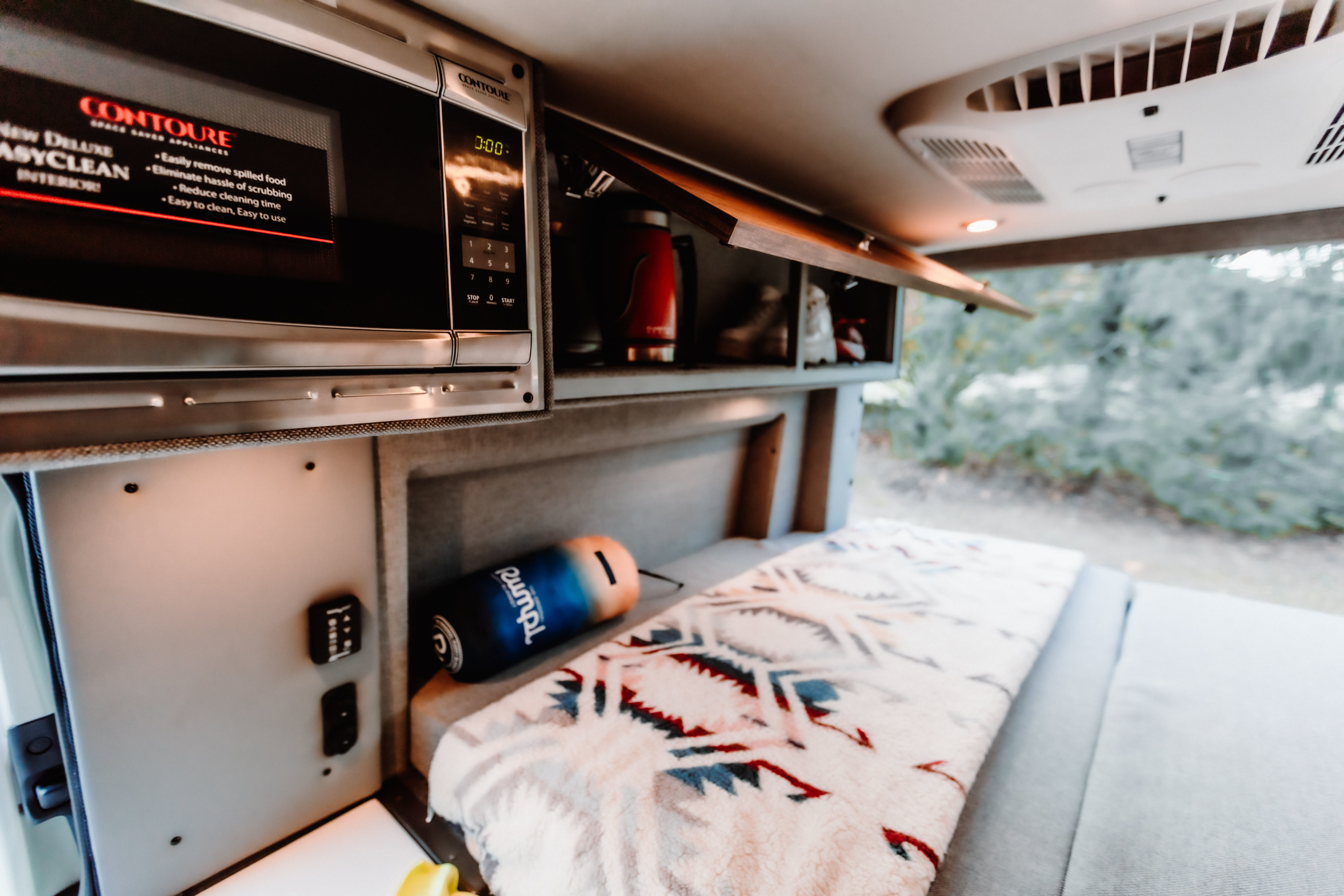 Experience comfort in your RV rental: Built-in microwave, ample storage, and a cozy bed with a soft blanket.. StoryTeller Overland Classic Mode 4X4 2022