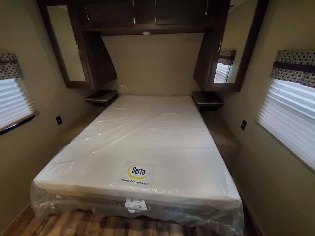 New RV rental bedroom: fresh mattress in plastic, overhead storage, side windows & nightstands.. Palomino 32DBKS 2017