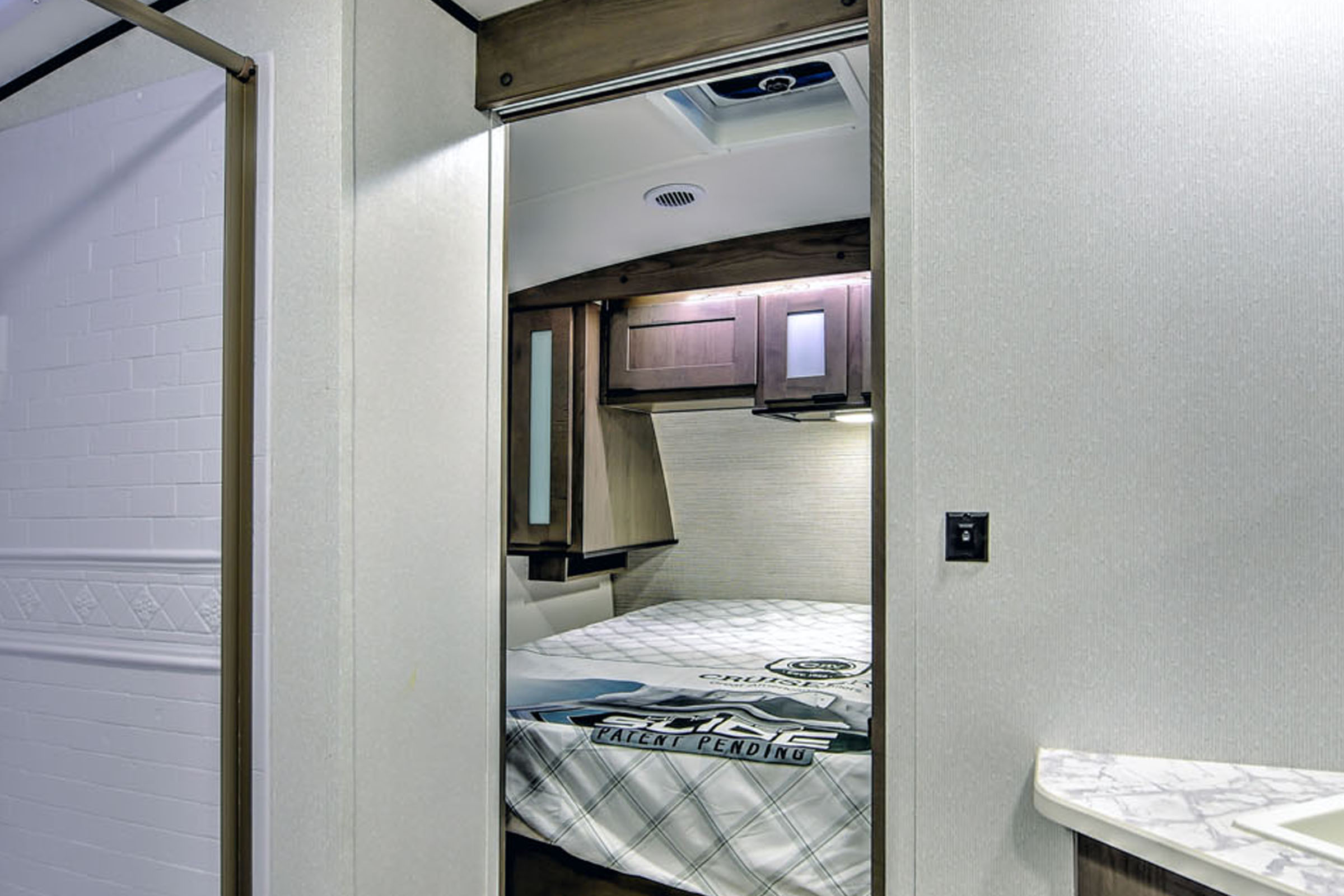 RV rental: View from living area into a modern bedroom with a bed & cabinets, adjacent to a shower & counter.. Cruiser RV MPG Ultra Lite 2022